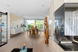 Een woning met een verhaal en uitzonderlijk veel ruimte. Deze karaktervolle eengezinswoning in naoorlogs modernistische stijl werd in 1970 ontworpen door architect <strong>Hubert Semal</strong> voor het echtpaar Celis, in samenwerking met beeldhouwer <strong>Albert Poels</strong>, bekend van de iconische Lange Wapper aan Het Steen. De uitgesproken architectuur, het gebruik van travertin, grote raampartijen en de verrassend doordachte indeling geven de woning tot vandaag een heel eigen karakter. Die eigenheid wordt mooi aangevuld door de ligging aan de Nieuwdreef: centraal in Merksem, met winkels, scholen, openbaar vervoer en belangrijke verbindingswegen vlot binnen bereik, terwijl ook parken en groenzones in de omgeving zorgen voor de nodige ademruimte.<br /><br /><strong>Indeling</strong><br />De woning is toegankelijk via de inkomhal met gastentoilet en vestiairegedeelte of rechtstreeks via de garage met automatische poort.<br />Op het gelijkvloers bevinden zich een polyvalente ruimte, momenteel ingericht als bureau, een wasplaats met lavabomeubel en de veranda met zicht op de zonnige zuidwestgerichte tuin.<br /><br />De<strong> eerste verdieping</strong> vormt het hart van de woning. De ruime en lichtrijke woonkamer met houthaard in travertin vloeit over in de eetruimte, waar een decoratieve travertinwand een uitgesproken architecturaal accent vormt. Aansluitend bevindt zich de kwalitatieve keuken met granieten werkblad. De leefruimtes zijn afgewerkt met een mooie strokenparket en beschikken zowel voor- als achteraan over een balkon.<br /><br />Op de<strong> tweede verdieping</strong> bevinden zich drie volwaardige slaapkamers, waaronder een royale hoofdslaapkamer met ensuite dressing. De badkamer beschikt over een douche in ligbad, lavabo en ingemaakte kasten. Daarnaast is er een afzonderlijk toilet.<br /><br />Ook de <strong>derde verdieping</strong> biedt nog eens drie slaapkamers, waarvan één bijzonder ruim, en een tweede volwaardige badkamer met douche in ligbad, lavabo en ingemaakte kasten. Ook op deze verdieping bevindt er zich een afzonderlijk toilet.<br /><br />De woning is bovendien <strong>volledig onderkelderd</strong> en biedt daardoor bijzonder veel extra ruimte voor hobby's, opslag of andere invullingen. Er is een lift verbindt oorspronkelijk alle bouwlagen tot en met de kelder.<br /><br /><strong>Bijzonderheden</strong><br />6 slaapkamers, 2 badkamers, EPC B, 16 zonnepanelen, elektriciteit zal conform worden afgeleverd, zonnige zuidwesttuin, polyvalente ruimte op het gelijkvloers en uitzonderlijke hoeveelheid bruikbare oppervlakte.