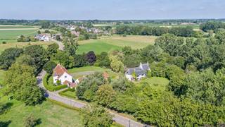 De kasteelhoeve beschikt over een bewoonbare oppervlakte van ca. 460 m² en verwelkomt u via een royale inkomhal met gastentoilet en vestiaire. Verder omvat het gelijkvloers een ruime keuken, een sfeervolle eetkamer, meerdere gezellige leefruimtes en een uitzonderlijk ruime woonkamer met open haard, die uitkijkt op het omliggende groen.<br /><br />Op de eerste verdieping bevinden zich een bureauruimte, vier volwaardige slaapkamers en twee badkamers, waaronder een stijlvolle master suite met aansluitende dressing en private badkamer. De tweede verdieping biedt plaats aan een vijfde slaapkamer en verschillende zolderruimtes met tal van mogelijkheden.<br /><br />Het authentieke waterkasteel heeft een oppervlakte van ca. 420 m² en straalt geschiedenis en elegantie uit in elk detail. Het omvat een inkomhal met gastentoilet, een indrukwekkende eetkamer, een lichtrijke woonkamer en een keuken. Daarnaast beschikt het kasteel over twee slaapkamers en twee badkamers. Verschillende polyvalente ruimtes, gekenmerkt door het prachtige authentieke gebinte, bieden tal van invullingen. De oorspronkelijke Romaanse kelder vormt zonder twijfel een uniek historisch element binnen dit uitzonderlijke geheel.<br /><br />Het domein wordt verder vervolledigd door een conciërgewoning met één slaapkamer en badkamer, een ruime garage met verdieping, authentieke paardenstallen en diverse ruime bijgebouwen.<br /><br />Bovendien bestaat de mogelijkheid tot aankoop van een aangrenzende boomgaard van ca. 1,5 hectare.<br /><br />Het betreft een overdracht van aandelen. De uiteindelijke waarde wordt bepaald op basis van de boekhouding van de vennootschap en de waardering van het onroerend goed zoals hierboven omschreven. De renovatieplicht is hier dan ook niet van toepassing aangezien het om een sharedeal gaat.<br /><br />EPC: 368 kWh/m² / UC: 20180808-0002080133-1<br />EPC: 443 kWh/m² / UC: 20180808-0002080131-1<br />EPC: 794 kWh/m² / UC: 20180808-0002080134-1<br /><br />Bestuursmaatregelen in het maatregelenregister: nee