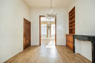 Op een rustige en centrale ligging, op wandelafstand van het stadscentrum, vinden we deze charmante herenwoning uit de eeuwwisseling. Een karaktervolle stadswoning met ca. 185 m² bewoonbare oppervlakte, een ruime kelder en een verrassend private stadstuin.<br />De woning ademt authenticiteit dankzij de hoge plafonds, originele houten en suite-deuren en plankenvloeren. Tegelijk biedt ze heel wat mogelijkheden om de woning verder te moderniseren en volledig naar eigen smaak in te richten.<br /><br />Via de inkomhal met vestiaire komen we op het gelijkvloers in de aangename, doorlopende leefruimte met een voorkamer, salon en eetkamer. De ingerichte keuken sluit hier mooi op aan en beschikt over een vaatwasser, ingebouwde microgolfoven en voldoende kastruimte. Achteraan bevindt zich de badkamer met ligbad, lavabo en toilet. Vanuit de leefruimte is er rechtstreeks toegang tot het vernieuwde terras en de gezellige, private tuin.<br /><br />Op de tussenverdieping bevinden zich twee kamers, waarvan één zich uitstekend leent om om te vormen tot een tweede badkamer. De eerste verdieping omvat twee ruime slaapkamers en een praktische wasplaats. Op de tweede verdieping bevinden zich nog twee ruime kamers met dakramen. Afhankelijk van de gewenste indeling zijn hier 4 tot 6 slaapkamers mogelijk.<br />Ook de kelder biedt heel wat extra ruimte: ca. 50 m² verdeeld over drie afzonderlijke ruimtes.<br /><br />De private stadstuin vormt een absolute troef. Met een vernieuwd terras van ca. 29 m², een tuinhuis en voldoende groen is dit een heerlijke plek om in alle rust te genieten, midden in de stad.<br /><br />Troeven:<br />Karaktervolle herenwoning uit de eeuwwisseling<br />Ca. 185 m² bewoonbare oppervlakte<br />Perceel van 184 m²<br />4 tot 6 slaapkamers mogelijk<br />Kelder van ca. 50 m²<br />Private stadstuin<br />Vernieuwd terras van ca. 29 m²<br />Authentieke houten elementen en hoge plafonds<br />Recent geschilderde gevel<br />Centrale ligging in 2060 Antwerpen<br />EPC-label F – interessant renovatiepotentieel<br /><br />Een woning met karakter, ruimte en mogelijkheden, ideaal voor wie op zoek is naar een authentieke stadswoning met tuin en deze volledig naar eigen smaak wil transformeren.<br /><br />De videotour, het grondplan, EPC, elektriciteitskeuring en asbestattest zijn beschikbaar via de Wellimmo-site onder ‘Documenten’.<br />Interesse? Contacteer Wellimmo Centrum via 03 225 00 68 of gerd@wellimmo.net voor meer informatie of een bezoek.