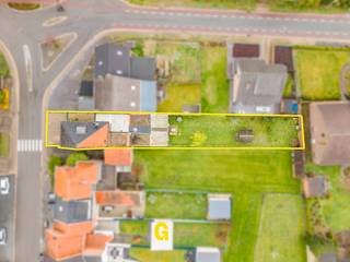 Met een bruikbare oppervlakte van maar liefst 293 m² biedt deze halfopen woning heel wat mogelijkheden voor wie op zoek is naar ruimte en een eigendom dat volledig naar eigen wensen kan worden ingericht. De woning bevindt zich langs de Groenstraat, op een perceel van 544 m², op korte afstand van zowel Hoeselt als Bilzen en met een vlotte aansluiting op de E313 richting Hasselt, Tongeren en Maastricht.<br /><br />Het gebouw deed jarenlang dienst als gekende slagerij. Die vroegere bestemming is vandaag nog merkbaar in de praktische indeling, waarbij de voormalige handelsruimte aan de straatzijde tal van mogelijkheden biedt. Ze kan opnieuw worden ingericht voor een zelfstandige activiteit, een vrij beroep of een ruime thuiswerkplek. Uiteraard kan het volledige gebouw ook perfect worden ingericht als ruime gezinswoning.<br /><br />Hoewel een grondige renovatie zich opdringt, vormt de degelijke basis een belangrijk uitgangspunt. De dakconstructie verkeert in goede staat en ook de elektrische installatie werd reeds aangepast, waarvoor een conformiteitsattest beschikbaar is. De ruime volumes laten bovendien toe om de woning volledig volgens de eigen woonwensen in te delen.<br /><br /><br />Indeling<br /><br />Gelijkvloers<br />De voormalige handelsruimte bevindt zich aan de voorzijde van het gebouw en sluit aan op de centrale hal. Verder omvat het gelijkvloers een zitruimte, een ruime kamer die zich uitstekend leent voor de inrichting van een open leefkeuken, een achterbouw met de huidige keuken, sanitaire voorzieningen en badkamer, een inpandige garage en de trap naar zowel de verdieping als de droge kelder.<br /><br />Verdieping<br />De eerste verdieping beschikt over drie volwaardige slaapkamers en een badkamer met douche en toilet. Vanuit de nachthal leidt een vaste trap naar de zolder.<br /><br />Zolder<br />De ruime zolderverdieping beschikt over een betonnen vloer en een degelijke dakconstructie. Hierdoor biedt deze verdieping interessante mogelijkheden voor bijkomende woonruimte, slaapkamers of een hobbyruimte.<br /><br />Buiten<br />Achter de woning ligt een volledig omheinde tuin met terras, waar voldoende ruimte is om een aangename buitenomgeving te creëren.<br /><br />Technische gegevens<br />-Bruikbare oppervlakte: 293 m²<br />-Perceeloppervlakte: 544 m²<br />-EPC: Label F – 804 kWh/m² per jaar<br />-Renovatieverplichting van toepassing<br />-Elektrische installatie conform<br />-Degelijke dakstructuur<br />-Droge kelder<br />-Inpandige garage<br /><br />Deze eigendom richt zich in het bijzonder tot kandidaten die op zoek zijn naar een ruim renovatieproject met veel potentieel. Dankzij de royale oppervlakte en de voormalige handelsruimte zijn uiteenlopende invullingen mogelijk, gaande van een ruime gezinswoning tot de combinatie van wonen en werken, afhankelijk van de eigen plannen en wensen. <br /><br />Een bezoek geeft pas echt een goed beeld van de ruimte en de mogelijkheden die dit eigendom te bieden heeft.