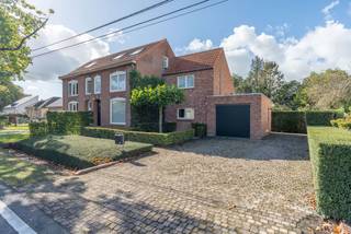 <p><strong>Een thuis waar jaren '30-charme en modern comfort elkaar vinden.</strong></p>
<p>Bent u op zoek naar een instapklare woning met karakter, ruimte en een heerlijke tuin vol privacy? Dan mag deze parel op een centrale locatie nabij het centrum van Poppel en de Nederlandse grens zeker niet ontbreken op uw bezichtigingslijst.</p>
<p>Deze woning, oorspronkelijk gebouwd in de jaren '30, werd in 1989 volledig verbouwd en uitgebreid.</p>
<p><strong>Gelijkvloers<br /></strong>Via de voordeur komt u binnen in een praktische inkomhal met inbouwkast. Maar de woning wordt voornamelijk via de achterzijde betreden, waar u meteen wordt verwelkomd door de mooie, groene achtertuin. De lichtrijke achterinkomhal baadt dankzij de raampartijen in het natuurlijk licht, waarbij het zonwerende glas zorgt voor een aangenaam binnenklimaat en een fraaie verbinding met de tuin.</p>
<p>De woonkamer met houten parketvloer en sfeervolle spotverlichting ademt warmte en gezelligheid uit, terwijl het elektrisch rolluik aan de voorzijde extra comfort en veiligheid biedt.</p>
<p>De landelijke keuken, met praktische tegelvloer, vormt een fijne en gezellige plek in de woning. Volop ruimte voor een eettafel, een bewust verlaagd kookgedeelte voor comfortabel koken, en een verrijdbaar keukeneiland dat moeiteloos plaatsmaakt wanneer u gasten ontvangt voor een etentje, kerstdiner of feestje. De keuken is bovendien uitgerust met kwalitatieve Miele-apparatuur (vaatwasser, oven, inductiekookplaat en cooker), vijf jaar geleden vernieuwd.</p>
<p>Verder op het gelijkvloers: een gastentoilet, een handige wasplaats met inbouwkasten en aansluitingen, en een badkamer (gerenoveerd 12 jaar geleden) met inloopdouche, wastafel met inbouwkasten en zelfs een ingebouwde plafondradio voor die extra touch. Via een vlizotrap vanuit de wasplaats bereikt u een eerste bergzolder.</p>
<p><strong>Verdieping<br /></strong>Deze verdieping biedt drie ruime slaapkamers, waaronder een master bedroom met airconditioning. Één slaapkamer geeft via een vlizotrap toegang tot een tweede bergzolder. Een apart toilet op de verdieping maakt het geheel helemaal af.</p>
<p><strong>Buitenruimte<br /></strong>Het absolute pluspunt van deze woning is de tuin. Op het terras kunt u heerlijk genieten van de schaduw en verkoeling onder de dakplatanen. Daarnaast biedt de tuin ook volop lekkers uit eigen omgeving, met rode bessen, witte frambozen en bramen.</p>
<p>Tegen de woning aan bevindt zich een extra berging met aansluitende overkapping. De ideale plek om te zitten en te genieten, met een prachtig overzicht over het volledige perceel. Liefhebbers van tuinieren komen helemaal aan hun trekken dankzij de eigen moestuin, en achteraan het perceel vindt u een kippenhok met tuinhuisje voor extra bergruimte.<br /><br /><strong></strong>Met een oprit voor maar liefst vier auto's en een garage met elektrische poort (plaats voor één wagen plus extra opslag), is parkeren hier geen enkel probleem.</p>
<p><strong>Een instapklare woning met karakter, comfort en een heerlijke groene tuin. Een plek waar u zich meteen thuis zult voelen.</strong></p>
<p>Wilt u deze woning zelf ervaren? Neem gerust contact met ons op voor een bezichtiging.<br /><br />Vermelde oppervlakten zijn indicatief. Oppervlakte conform EPC.</p>