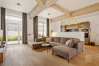 Prachtige instapklare gelijkvloerse loft van 240 m² met ruim terras en parkeerplaats!Gelegen in Ruien, aan de voet van de prachtige Vlaamse Ardennen, bevindt zich deze uitzonderlijk ruime en perfect onderhouden gelijkvloerse loft. Met een bewoonbare oppervlakte van maar liefst 240 m², indrukwekkende plafondhoogtes van 3,30 m en een prachtig terras van 40 m² geniet u hier van een unieke combinatie van ruimte, licht en comfort.Via de inkomhal met gastentoilet bereikt u de royale en lichtrijke leefruimte met open keuken, waar de hoge plafonds zorgen voor een uitzonderlijk ruimtegevoel. Verder beschikt de loft over 3 volwaardige slaapkamers, een comfortabele badkamer met zowel ligbad als douche en een praktische berging.Een absolute extra troef is de halfondergrondse verdieping van maar liefst 60 m². Deze multifunctionele ruimte biedt tal van mogelijkheden als hobbyruimte, wellness met sauna, ontspanningsruimte of extra bergruimte.Buiten geniet u van een heerlijk terras van 40 m², waarvan een gedeelte overdekt is. Daarnaast zijn er 2 private parkeerplaatsen beschikbaar.Dankzij de zonnepanelen van 3.900 W en het uitstekende EPC-label A (78 kWh/m²) geniet u bovendien van een bijzonder energiezuinige eigendom. Er is geen syndicus; enkel het dak en de gevels zijn gemeenschappelijk.De loft is verhuurd sinds 1 juni 2023 en genereert momenteel een maandelijkse huurinkomst van € 1.006,38. Hierdoor vormt deze eigendom ook voor investeerders een interessante opportuniteit. Ideaal voor wie op zoek is naar een uitzonderlijk ruime, instapklare en energiezuinige loft met tal van mogelijkheden, of voor investeerders die een unieke eigendom met bestaande huurinkomsten wensen.Vraagprijs: € 425.000, inclusief één parkeerplaats. Een tweede parkeerplaats kan mee opgenomen worden in de onderhandelingen.Meer info of een bezoek via emmy@immobeguin.beTe koop via Immo Beguin, jouw vastgoedexpert sinds 2009, met kantoren in Ronse, Waregem, Kortrijk, Deinze, Doornik, Lessines, Moeskroen en Nieuwpoort.