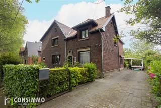 Bent u op zoek naar een woning met karakter? Deze authentieke mijnwoning aan de Wildekerslaan 29 in Genk is gelegen in de gegeerde tuinwijk van Waterschei en combineert het typische karakter van de mijnarchitectuur met hedendaags wooncomfort en energetische verbeteringen.<br /><br />Indeling<br />Via de inkomhal betreedt u de woning met toegang tot de leefruimte, keuken en badkamer op het gelijkvloers.<br /><br />Op de eerste verdieping bevinden zich drie slaapkamers en een tussenkamer dat kan dienen als bureau of dressing. Daarnaast beschikt de woning over een praktische kelder en een zolderruimte, wat zorgt voor extra opslag- of uitbreidingsmogelijkheden.<br /><br />Buiten geniet u van een overdekt terras en een aangename zuidgerichte tuin die zich perfect leent als siertuin of moestuin. Verder beschikt het perceel over een dubbele garage, bereikbaar via een achterliggende servitudewe, en een oprit die kan dienen als bijkomende parkeergelegenheid.<br /><br />Technische informatie<br />De woning werd de afgelopen jaren zowel technisch als energetisch aangepakt. Zo werd recent het dak volledig vernieuwd en geïsoleerd, waarbij het hellend dak voorzien werd van 22 cm minerale wol en het plat dak van 10 cm PUR-isolatie. Daarnaast werden de ramen vorig jaar grotendeels vervangen door pvc-profielen met superisolerend hoogrendementsglas. De verwarming gebeurt op stookolie en er is eveneens een warmtepomp-airco aanwezig die zowel kan koelen als verwarmen. De woning behaalt een EPC-label D met een score van 319, waardoor er geen renovatieverplichting geldt.<br /><br />Buurtinformatie<br />De woning is gelegen in een groene en karaktervolle omgeving in de authentieke tuinwijk van Waterschei, een buurt met een rijk historisch mijnverleden en een unieke uitstraling. In de nabije omgeving bevinden zich winkels, supermarkten en openbaar vervoer. Daarnaast woont u vlakbij de levendige Stalenstraat met tal van handelszaken, horeca en buurtvoorzieningen. Ook recreatieve trekpleisters zoals Thor Park, SportinGenk Park en het stadion van KRC Genk bevinden zich op korte afstand, terwijl de verbinding naar het centrum van Genk en de omliggende gemeenten bijzonder vlot verloopt. Ook het scholencampus van Genk is op fietsafstand gelegen.<br /><br />Bent u op zoek naar een karaktervolle woning met een hedendaags comfort in Genk? Contacteer ons via 089 69 30 01 of info@consimmo.be voor meer informatie of een bezoek ter plaatse. Bekijk ook de virtuele tour op onze website www.consimmo.be.