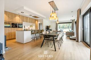 Voor meer info en foto’s, surf naar www.swevers.be – deze recente halfopen bebouwing in de Stationsstraat 85 D in Houthalen-Helchteren combineert ruimte, comfort en energiezuinig wonen op een uitstekende locatie. De woning werd gebouwd in 2019, is volledig instapklaar en afgewerkt met kwalitatieve, neutrale materialen. Met een bewoonbare oppervlakte van 203 m² op een zuidgericht perceel van 1.266 m² geniet u hier van veel licht, een praktische indeling en een aangenaam gevoel van rust. Vergis u niet, de tuin loopt volledig door tot achteren waardoor u op uw eigen perceel volop van de natuur kan genieten of de kinderen in alle vrijheid kunnen ravotten. Op het gelijkvloers komt u binnen via de inkomhal met gastentoilet. Verder vindt u een ruime wasplaats, een ruime bureauruimte die ook kan dienen als gelijkvloerse slaapkamer, en een lichtrijke leefruimte van ongeveer 40 m² met zicht op terras en tuin. De open keuken van 14 m² is volledig uitgerust met hoogwaardige toestellen, waaronder een stoomoven, heteluchtoven, koffieapparaat, vaatwasser en inductiekookplaat. Aansluitend zijn er nog een berging en een extra hal met ingemaakte kasten. De verdieping telt nog vier volwaardige slaapkamers van 14 m², 12 m², 10,60 m² en 10,60 m², een extra bergruimte, een badkamer met douche en dubbele lavabo, en een apart toilet. Dankzij de vele praktische bergruimtes is elke vierkante meter optimaal benut. Buiten geniet u van een ruime, zuidgerichte tuin met blijvend groen verzicht achteraan door het aangrenzende agrarische gebied. Extra troeven zijn vloerverwarming, zonnepanelen, warmtepomp, domotica, videofoon, screens aan de achterzijde en een elektrische poort. Winkels, scholen, openbaar vervoer en snelwegen bevinden zich vlakbij. Voor meer informatie, bel 011 255 155. Bron bewoonbare oppervlakte: EPC – verslag.