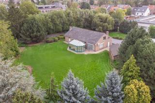 <h1><span>UITZONDERLIJK VASTGOED – Ruime bungalow met vergunde loods van ca. 400 m² op een prachtig domein van 44a 35ca!</span></h1><p><span><strong>UNIEKE OPPORTUNITEIT VOOR ZELFSTANDIGEN, ONDERNEMERS OF WIE WONEN EN WERKEN WIL COMBINEREN!</strong></span></p><p><span>Bent u op zoek naar een eigendom met uitzonderlijk veel ruimte, privacy en tal van mogelijkheden? Dan is dit unieke vastgoed beslist een bezoek waard!</span></p><p><span>Via een private oprijlaan bereikt u het <strong>volledig omheinde domein van maar liefst 44a 35ca</strong>, afgesloten met een elektrische toegangspoort. Het uitgestrekte terrein biedt volop parkeergelegenheid en beschikt over een <strong>vergunde loods/atelier van ca. 400 m²</strong>, ideaal voor zelfstandigen, ondernemers, opslag of diverse professionele activiteiten.</span></p><p><span>Naast de loods bevindt zich een ruime, vrijstaande bungalow uit 1973 met een gelijkvloerse oppervlakte van ca. 200 m² en een bijkomende zolderruimte van maar liefst 110 m².</span></p><p><span>De woning verwelkomt u via een ruime inkomhal met gastentoilet en leidt naar een gezellige leefruimte van met open haard. De ingerichte keuken sluit aan op de prachtige tuinkamer, waar u dankzij het panoramische uitzicht volop geniet van de rust en het groen van de omliggende tuin met zuidwest oriëntatie.</span></p><p><span>Verder beschikt de woning op het gelijkvloers over drie slaapkamers , een badkamer met toilet, een praktische wasplaats en een inpandige garage. Een absolute meerwaarde is de ruime zolderverdieping van ca. 110 m², bereikbaar via een vaste trap. Deze ruimte biedt de mogelijkheid voor <strong>extra kamers</strong> of andere multifunctionele ruimtes te creëren.</span></p><p>Contacteer ons voor een bezoek! Bel 016 229 228 of mail office@connct-immo.be <br />EPC: 329 kWh/m² - label D - UC 3952271<br />Wg-Gdv-Gvkr-Gvv</p>