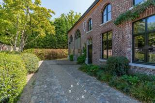 Deze uitzonderlijke woning is discreet gelegen aan het einde van een doodlopende straat in het rustige en groene Loppem, een ideale plek voor wie op zoek is naar rust en ruimte vlakbij de stad. De omgeving biedt een perfecte balans tussen natuur en bereikbaarheid. Het in parkgebied gelegen perceel van maar liefst 2.656 m² geeft u alle vrijheid om volop te genieten van privacy en buitenleven.<br /><br />Deze parel straalt karakter en comfort uit, met een bewoonbare oppervlakte van 600 m² verdeeld over 3 verdiepingen. Zowel binnen als buiten is bijzondere aandacht besteed aan kwaliteit en functionaliteit. Met 4 parkeerplaatsen een extra gemak en veiligheid. De combinatie van ruime leefruimtes en praktische buitenruimtes maakt dit huis ideaal voor gezinnen die comfort en ruimte wensen, vrij beroep,...<br /><br />De indeling van de woning en bijgebouwen omvat onder andere:<br /><br />Gelijkvloers:<br />- ruime inkom met gastentoilet, aparte inkom met mudroom of ruime ontvangstruimte<br />- bureauruimte met gashaard (kan omgevormd worden tot slaapkamer met sanitair)<br />- wasruimte<br />- koelcel<br />- corridor als verbinding tussen de verschillende leefruimten<br />- woonruimte<br />- eetruimte in moderne uitbouw<br />- ruime aangelegde tuin met verschillende terrassen, zwemvijver, eiken bijgebouw, boogserre<br />- 4 parkeerplaatsen op eigen terrein <br /><br />1e Verdiep:<br />- masterbedroom met eigen badkamer , apart toilet en ruime dressing<br />- 5 ruime slaapkamers, ideaal voor een groot gezin of thuiswerkplekken <br />- 2 douchekamers<br />- 2 toiletten<br />(2 slaapkamers kunnen samengevoegd worden tot leefruimte (voorzieningen voor extra keukenblok))<br /><br />2e Verdiep:<br />- 2 slaapkamers met douchekamer en eigen toilet<br /><br />Verder is de kelder voorzien van een ingerichte wijnkelder. <br /><br />De troeven van deze woning:<br />- vlotte verbinding naar de stad en de kust<br />- uitzonderlijke afwerking van kelder tot en met 2e verdieping<br />- sterke beleving, perfecte samenhang tussen authenciteit en moderne elementen<br />- ruim uitgebreid domotica systeem, centraal stofzuigersysteem<br />- ruime koelcel<br />- hyper uitgeruste keuken (Molteni, VZUG, Liebherr)<br />- prachtige wijnkelder met koeling <br />- 4 haarden (combinatie van gas en hout)<br />- zwemvijver<br />- verschillende leefterrassen <br /><br />