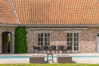 Te koop: charmante hoeve met zwembad op 3500m2 in Kruisem. Vanafprijs €998.500. In het landelijke en gegeerde Kruisem bevindt zich deze prachtige hoeve op een uitzonderlijk perceel van maar liefst 3500 vierkante meter. De eigendom, gebouwd in 1989, geniet van een volledig privatieve ligging en wordt omgeven door een mooie en ruime tuin, waardoor rust en privacy hier centraal staan.Bij het betreden van de woning ervaar je meteen het aangename ruimtegevoel en de authentieke charme. De lichtrijke leefruimtes bieden een prachtig zicht op de tuin en het zwembad, dat zonder twijfel één van de absolute troeven van deze eigendom vormt. De woning beschikt bovendien over voldoende ruimte en mogelijkheden om een vrij beroep te combineren met wonen, wat dit pand extra interessant maakt voor zelfstandigen of thuiswerkers.De uitgestrekte tuin en het ruime perceel bieden tal van mogelijkheden voor hobby’s, dierenliefhebbers of wie gewoon wil genieten van rust en natuur in alle privacy. Dankzij de gunstige ligging combineert deze hoeve landelijke rust met een vlotte bereikbaarheid.Een unieke eigendom voor wie op zoek is naar ruimte, privacy en veelzijdigheid.Interesse? Contacteer arne@immobeguin.be