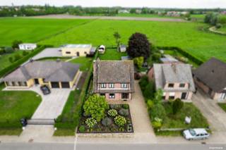 Deze open bebouwing geniet van een rustige ligging met een prachtig landelijk uitzicht over de achterliggende weilanden en bevindt zich tegelijk vlakbij het centrum en alle voorzieningen.<br />Bij het betreden van de woning komt u in de inkomhal met gastentoilet, waarna u doorloopt naar de ruime en lichtrijke woonkamer met haard en de vernieuwde, volledig ingerichte keuken met aansluitende berging.<br />De royale veranda van ca. 40 m² met pelletkachel vormt een volwaardige leefruimte en biedt een mooi zicht op de tuin en het omliggende groen.<br />Op de eerste verdieping bevinden zich drie volwaardige slaapkamers (19,5 m² – 17,4 m² – 15,15 m²), een deels vernieuwde badkamer en een praktische wasplaats/berging.<br />Via een luik met valtrap bereikt u de ruime zolder die extra opbergruimte biedt.<br />De voormalige garage werd omgevormd tot een afzonderlijke studio met eigen slaapkamer en badkamer, en achteraan bevindt zich nog een berging ingericht als gezellige buitenbar.