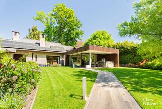 
Gelegen in een van de mooiste dreven van het Bois de Strihoux op een perceel van 26 are biedt deze ruime villa veel wooncomfort, privacy en tal van mogelijkheden.

De woning omvat op het gelijkvloers een royale inkomhal met toilet, een ruime woonkamer met eetplaats, keuken en een slaapkamer die eveneens perfect dienst kan doen als bureau. De aanbouw creëert extra leefruimte en kan ingericht worden als tweede woonkamer, praktijkruimte, gastenverblijf of bijkomende slaapkamer. Hier bevinden zich tevens een douchekamer met inloopdouche en wastafel en een sauna.

Via de keuken bereikt u de praktische berging/wasplaats en de inpandige garage.

Op de verdieping bevinden zich drie slaapkamers en een ruime badkamer met ligbad, douche, dubbele wastafel en toilet.

Buiten beschikt de woning over een ruime oprit voor meerdere wagens en een **carport met atelier**. De leefruimtes sluiten aan op de tuin, waar een gezellige tuinsphere zorgt voor een comfortabele buitenruimte die vrijwel het hele jaar bruikbaar is.

Dankzij de ruimtes op het gelijkvloers is deze villa bovendien bijzonder geschikt voor een vrij beroep of thuiskantoor.

Troeven:topligging in het Bois de Strihoux – perceel 26 are – 4 slaapkamers – sauna – garage – carport met atelier – ruime parking – geschikt voor vrij beroep – gunstig EPC B.

Informatie en oppervlaktes zijn louter indicatief en houden geen juridische verbintenis in.

