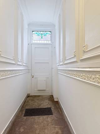 Dit statige herenhuis geniet van een uitzonderlijke ligging aan het Zuidpark in Gent en combineert authentieke charme met hedendaags comfort. De woning beschikt over een ruime kelder, een binnenplaats met parkeerplaats voor twee wagens, een recent geïnstalleerde elektrische laadpaal, zonnepanelen en een overdekt terras.<br /><br />Via de elektrisch bediende voordeur betreedt u de indrukwekkende inkomhal. Op het gelijkvloers bevindt zich een ruim bureau met aparte kantoorkeuken en afzonderlijk toilet. Deze verdieping leent zich perfect voor de uitoefening van een vrij beroep of praktijk aan huis. De kantoorkeuken biedt bovendien directe toegang tot de binnenplaats, de kelder en de bovenliggende verdiepingen via de statige trap.<br /><br />Op het tussenverdiep bevinden zich een ruime berging, vestiaire en een apart toilet.<br /><br />De eerste verdieping vormt het hart van de woning met een royale eetkamer, een tweede volledig uitgeruste keuken en een bijzonder ruim salon dat geniet van een adembenemend uitzicht over het Zuidpark.<br /><br />De tweede en derde verdieping herbergen samen vier volwaardige slaapkamers, een badkamer, een dressing en een afzonderlijk toilet. Op de vierde verdieping bevindt zich een ruime zolderverdieping met potentieel voor de inrichting van twee extra kamers en een bijkomende ruimte voorzien van een lavabo.<br /><br />Deze karaktervolle herenwoning werd oorspronkelijk gebouwd in 1863 en werd doorheen de jaren met zorg gerenoveerd, waarbij tal van authentieke elementen bewaard zijn gebleven. Het resultaat is een unieke eigendom met een uitzonderlijke uitstraling, royale volumes en tal van mogelijkheden voor zowel privégebruik als een combinatie van wonen en werken.