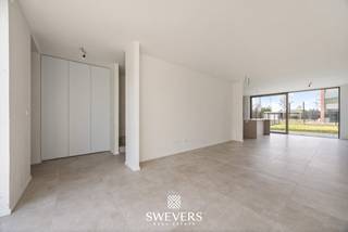 In het rustige, maar vlot bereikbare Leopoldsburg wacht een nieuwbouwwoning die comfort en functionaliteit combineert in een hedendaagse vormgeving. Deze woning biedt een ideale thuisbasis voor wie op zoek is naar kwaliteit, ruimte en een goede ligging, met alle voorzieningen binnen handbereik.<br />De halfopen bebouwing werd opgetrokken in 2025 en bevindt zich in een volledig nieuwe staat. Dankzij een bewoonbare oppervlakte van 144,44 m², verdeeld over twee volwaardige bouwlagen, geniet je hier van een goed doordachte indeling en een eigentijdse afwerking. De woning is voorzien van een carport en heeft een open en luchtige uitstraling.<br /><br />Op de gelijkvloerse verdieping vormt de leefruimte van 23,35 m² het centrale punt van het huis. Aansluitend bevindt zich een ruime eetruimte van 14,17 m², met directe verbinding naar de open keuken van 10,32 m². Samen vormen deze ruimtes een vloeiende leefomgeving waar koken, eten en ontspannen harmonieus samenkomen. Een schuifraam geeft uit op het terras, wat zorgt voor een natuurlijke lichtinval en een mooie connectie met buiten. Verder bevinden zich op deze verdieping een inkomhal van 4,30 m², een praktische berging van 3,52 m² en een gastentoilet van 1,53 m². Alles is logisch ingedeeld met oog voor dagelijks comfort.<br /><br />De eerste verdieping telt drie slaapkamers met oppervlaktes van respectievelijk 14,02 m², 12,38 m² en 9,98 m². Deze ruimtes bieden volop mogelijkheden voor een masterbedroom, kinderkamers of een thuiskantoor. De nachthal van 7,73 m² verbindt alle ruimtes efficiënt met elkaar. Daarnaast vind je op deze verdieping een aparte badkamer van 4,45 m² en een afzonderlijk toilet van 1,48 m². Ook werd er aan extra opbergruimte gedacht dankzij een berging van 4,47 m².<br /><br />Het perceel van 291 m² is zuidoostelijk georiënteerd. Dat betekent genieten van ochtend- en middagzon in de tuin. Een ideale ligging voor wie graag ontbijt in het zonnetje of een rustige middag op het terras waardeert. De oriëntatie laat bovendien mooie tuinplannen toe, zoals een loungehoek, moestuin of speelruimte.<br />Andere kenmerken zoals domotica of ventilatiesystemen werden niet vermeld, dus deze worden hier niet besproken.<br /><br />De woning bevindt zich op slechts 200 meter van scholen, ideaal voor jonge gezinnen. Ook het station ligt op amper 650 meter, wat zorgt voor een vlotte verbinding met andere steden. Met de snelwegen op minder dan 10 km afstand ben je bovendien goed ontsloten richting omliggende gemeenten. Voor wie graag ontspant, shopt of uit eten gaat: het centrum met winkels, restaurants en vrijetijdsopties ligt op slechts 1 km.<br /><br />Bovendien biedt deze woning een voordelig fiscaal voordeel: de grondwaarde bedraagt € 80 000 (12% registratierechten), terwijl de constructiewaarde van € 269 500 onder het 6 % btw-tarief valt.<br /><br />Deze nieuwbouwwoning in Leopoldsburg combineert een doordacht ontwerp met een praktische ligging en moderne woonkwaliteit. Maak vandaag nog een afspraak voor een persoonlijke rondleiding. Contacteer ons via 011 255 155. Bron bewoonbare oppervlakte: EPC – verslag.