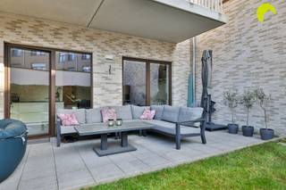 <p><span>Dit recent gebouwde gelijkvloers appartement met ruime zonnige tuin, kelderberging en ondergrondse parkeerplaats vinden we pal in het centrum van Wilrijk. Vanuit deze locatie zijn dagelijkse winkels, scholen en openbaar vervoer te voet te bereiken. </span></p><p><span>Het gebouw werd recent opgericht in 2019 en voldoet dus aan alle moderne normen. De maandelijkse kosten bedragen slechts 107,85 euro per maand en omvatten de blokpolis, ereloon syndicus en het onderhoud van de lift en gemene delen.</span></p><p><span>Via een automatische sectionaalpoort kan je binnenrijden naar de ondergrondse parkeerplaats die met de lift ook vanuit de gemeenschappelijke inkomhal bereikbaar is. Daarnaast heb je nog een handige private kelderberging én is er een gemeenschappelijke fietsenstalling in het gebouw.</span></p><p><span> </span></p><p><span>Indeling:</span></p><p><span>We komen binnen in de inkomhal van het appartement. Hier vinden we een vestiairekast en een apart toilet met lavabo.</span></p><p><span>Bij het betreden van de leefruimte valt meteen de royale lichtinval dankzij de plafondhoogte van maar liefst 3 meter op!</span></p><p><span>Van hieruit heb je toegang tot de zuidwest-gerichte tuin met aangelegd en overdekt terras. Je geniet hier van een zalig namiddag- en avondzonnetje met een minimum aan inkijk.</span></p><p><span>De open keuken van Augustijns is voorzien van een composieten werkblad, een vaatwasser, koel-vrieskast, combi-oven en Bora inductie kookplaat met geïntegreerde dampkap.</span></p><p><span>Centraal in het appartement is er de badkamer met ruime inloopdouche en lavabomeubel met spiegelkast.</span></p><p><span>In de nachthal is er nog een handige bergkast met aansluiting voor de wasmachine, de CV-condensatieketel en ventilatie.</span></p><p><span>Vooraan zijn er 2 slaapkamers. De onderhoudsvriendelijke keramische tegelvloer loopt door over het hele appartement.</span></p><p><span> </span></p><p><span>Kortom, dit instapklare gelijkvloers appartement heeft alle troeven in handen!</span></p><p><span> </span></p><p><span>Samengevat:</span></p><p><span>- Recent gebouw met lage maandelijkse kosten</span></p><p><span>- Rustige ligging maar vlakbij alle nodige faciliteiten</span></p><p><span>- Uiterst gunstig EPC, overal vloerverwarming en conforme elektriciteit</span></p><p><span>- Zalige zonnige tuin, ondergrondse parkeerplaats, private berging</span></p><p><span> </span></p><p><span>EPC: 58 kWh/m² - label A  °  Elektriciteit conform</span></p><p><span>P-score A - G-score A</span></p><p><span> </span></p><p><span>Voor een bezoek ter plaatse kan u ons contacteren op het nummer 03 449 42 41 of mail ons via <span>hallo@habicom.be</span></span></p><p><span>Benieuwd naar de waarde van jouw woning?  Check het gratis op <span>www.watismijnhuiswaard.be</span></span></p><p><span> </span></p>