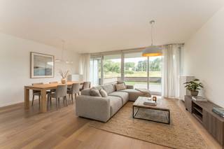 Op een toplocatie, op wandelafstand van Bredene-aan-Zee, bevindt zich dit prachtig afgewerkte gelijkvloerse appartement. Hier geniet u van de perfecte combinatie van rust en bereikbaarheid, met winkels, gezellige horecazaken, de zee én de uitgestrekte duinen binnen handbereik.<br />Een absolute troef is het ruime voorterras, waar u in alle rust kunt genieten van een weids, open zicht op de duinen. Dit unieke uitzicht zorgt elke dag opnieuw voor een heerlijk vakantiegevoel.<br /><br />Dankzij de ligging op het gelijkvloers is het appartement bijzonder vlot toegankelijk. Bovendien werd het met veel zorg afgewerkt, waarbij gekozen werd voor kwalitatieve materialen, een stijlvolle uitstraling en talrijke praktische inbouwkasten.<br /><br />De lichtrijke leefruimte vormt het hart van de woning. De grote raampartijen zorgen voor een aangename lichtinval en creëren een ruimtelijk gevoel. Hier vindt u voldoende plaats voor een gezellige zithoek en een ruime eetplaats, met directe toegang tot het zonnige voorterras en het prachtige uitzicht op de duinen.<br /><br />De open keuken sluit naadloos aan op de leefruimte en is volledig uitgerust met kwalitatieve toestellen en veel kastruimte, ideaal voor wie comfort en functionaliteit weet te waarderen.<br /><br />De moderne badkamer beschikt over een stijlvolle inloopdouche en een lavabo.<br /><br />Achteraan bevinden zich twee volwaardige slaapkamers, beide met toegang tot een tweede, rustig gelegen terras. Dankzij de terrassen aan zowel de voor- als achterzijde kunt u op elk moment van de dag genieten van zon of schaduw, volledig naar wens.<br /><br />Verder beschikt het appartement over een praktische berging met aansluiting voor wasmachine en droogkast.<br /><br />Als extra is er de mogelijkheid om een garagebox aan te kopen voor € 32.000. Daarnaast zijn er een gemeenschappelijke fietsenberging en afvalberging aanwezig.<br /><br />Kortom, een instapklaar appartement op een uitstekende ligging, met een hoogwaardige afwerking, twee zonnige terrassen én een open zicht op de duinen.