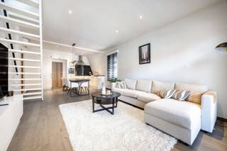 Rustig wonen in het hart van Turnhout, met alle voorzieningen op wandelafstand? Dit lichtrijke en instapklare eigendom vormt een unieke combinatie tussen een bel-etage en een duplexappartement. De royale woonoppervlakte (163m2), de verschillende niveaus en de vele praktische ruimtes zorgen voor bijzonder veel mogelijkheden en een uiterst aangenaam woongevoel.

Het appartement werd grondig gerenoveerd. In 2018 werden onder meer de keuken, de badkamer en het afzonderlijke toilet volledig vernieuwd. De condenserende gasketel dateert van 2017 en in 2019 werd een lucht-luchtwarmtepomp met verwarmings- en aircofunctie geplaatst. Het geheel werd zorgvuldig onderhouden en is werkelijk instapklaar.

Op de eerste verdieping bevindt zich de ruime en lichtrijke leefruimte met grote raampartijen en een stijlvolle parketvloer. De living biedt alle ruimte voor een volwaardige zit- en eethoek en sluit mooi aan op de open, volledig ingerichte keuken. Deze beschikt over veel kastruimte, een royaal werkblad en een praktische inrichting.

De ruime slaapkamer is eveneens afgewerkt met parket en beschikt over een prachtige dressing en rechtstreekse toegang tot het terras. De handige mezzanine biedt bijkomende mogelijkheden als logeerplek, leeshoek of extra bergruimte.

De tijdloze badkamer is ingericht met een dubbele wastafel, een ligbad en een afzonderlijke douche. Daarnaast is er een apart toilet met eigen wastafel.

Via de trap vanuit de woonkamer bereikt u de tweede verdieping, waar zich een royale polyvalente kamer bevindt (extra slaapkamer, bureau, of hobbyruimte).

Op het gelijkvloers beschikt het eigendom over een garage met automatische poort (verplicht samen met het appartement te worden aangekocht).

Daarnaast is er een uitzonderlijk ruim en polyvalent magazijn met een hoge industriële toegangspoort. Deze ruimte is ideaal voor opslag van materiaal/voertuigen of uitgebreid hobbygebruik en vormt een bijzonder zeldzame meerwaarde op deze centrale locatie.

Verder beschikt het appartement over zonnepanelen, een condenserende gasketel en een lucht-luchtwarmtepomp, wat leidt tot een gunstige EPC B-score.

Een uniek eigendom voor wie centraal en stijlvol wil wonen, met het comfort en de beleving van een woning, gecombineerd met de praktische voordelen van een duplexappartement.

Vraagprijs appartement: € 275.000
Garage met automatische poort, verplicht bij aan te kopen: € 30.000
Ruim magazijn met industriële poort: € 55.000