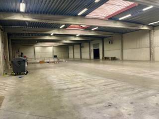 Samengesteld uit twee productiehallen van 933 m² en 1.000 m², met een vrije hoogte onder dak van ca. 5,50 m.
Vlotte toegang via twee sectionale poorten, waarvan één met inpandige laad- en loskade. De achterste hal is uitgerust met 6 airconditionings.
Een administratieve zone omvat:
een inkomhal,
twee kantoren,
een bergruimte,
sanitaire voorzieningen en kleedkamers H/D,
evenals een refter met kitchenette.
Het gebouw is opgetrokken in een betonnen structuur met gladde industriële betonvloer, betonnen gevels en een vlakke metalen dakconstructie. Verwarming via twee mazoutketels (kantoren en hallen).
Technische installaties aanwezig (elektriciteit, sanitair, alarm, hydranten).
Buiten: geasfalteerde parkeer- en toegangswegen, oprijlaan naar de laad- en loskade, groenzone.
👉 Functioneel bedrijfsgebouw met ruime volumes en groot potentieel voor industriële of logistieke activiteiten.