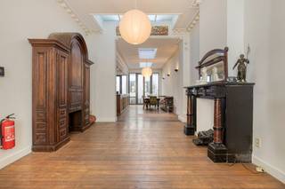 Karaktervolle en ruime herenwoning met tal van originele elementen zoals authentieke schoorsteenmantels, moulures, rozetten en planchetvloeren.<br />Indeling:<br />Gelijkvloers: statige inkomhal op marmeren vloer, ruime woonkamer en eetkamer met veel natuurlijke lichtinval dankzij de lichtkoepels, aansluitend een open keuken en een gezellig buitenruimte.<br />Tussenverdieping: apart toilet, badkamer met ligbad, douche en achterliggende praktische linnenkamer.<br />Eerste verdieping: twee ruime slaapkamers en een terras.<br />Tweede terras op het dak van de eerste tussenverdieping.<br />Tweede verdieping: voorzien van kitchenette en slaapkamer/woonkamer.<br />Zolderverdieping: extra slaapkamer en badkamer met ligbad en toilet.<br />Ruime kelder.<br />Gelegen op wandelafstand van Park Spoor Noord, combineert deze woning authentieke charme met een functionele indeling en tal van mogelijkheden.