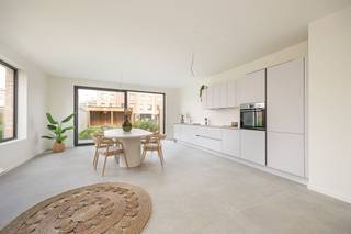 <p><span> </span></p><p><span>Droom je van een nieuwbouwwoning zonder aankoop onder btw-stelsel? Dan is dit je kans. In deze recent opgeleverde woning geniet je van alle hedendaagse comfort – warmtepomp, vloerverwarming, ventilatiesysteem, zonnepanelen en een E-peil onder 30 – waar je uitzonderlijk registratierechten op kan betalen. Gelegen in een rustige, doodlopende straat temidden het Boekenbergpark en Te Boelaerpark, woon je hier in een</span><span> </span><span>gezellige woongemeenschap en groene buurt met alle voorzieningen vlakbij. XL-staanplaats optioneel aan te kopen (€ 25.000).</span></p><p><span> </span></p><p><span>Licht, ruimte & hedendaags comfort</span></p><p><span>Van zodra je binnenkomt, valt de royale inkomhal op. De stijlvolle XL-tegelvloer loopt door over het volledige huis en zorgt voor een strak en tijdloos geheel. Er is meer dan voldoende plaats voor een vestiaire, terwijl aan de overzijde nog ruimte overblijft voor een speelhoek of een compacte thuiswerkplek. Links bevindt zich het gastentoilet met hangtoilet en lavabo.</span></p><p><span>Rechtdoor stap je de indrukwekkende leefkeuken binnen. Dankzij de hoekligging, het extra zijraam en het grote schuifraam naar de tuin baadt deze ruimte de hele dag in het natuurlijke licht. Binnen en buiten lopen hier naadloos in elkaar over. De moderne keuken is volledig uitgerust met Whirlpool-toestellen, waaronder een koelkast, diepvries met drie lades, combi-oven, vaatwasser, inductiekookplaat en een ruime spoelbak. Aansluitend bevindt zich de technische ruimte, waar alle technieken netjes zijn ondergebracht: ventilatiesysteem, aansluiting was-droogcombinatie, warmtepomp, omvormer van de zonnepanelen en de nutsvoorzieningen.</span></p><p><span> </span></p><p><span>Vier volwaardige slaapkamers en twee badkamers</span></p><p><span>Op de eerste verdieping bevindt zich de royale leefruimte aan de voorzijde van de woning. Dezelfde stijlvolle XL-tegelvloer loopt hier naadloos door en, in combinatie met de grote raampartijen, zorgt dit voor een aangename lichtinval en een heerlijk ruimtelijk gevoel. Achteraan vindt u de eerste slaapkamer: een comfortabele master bedroom met een prachtig uitzicht op de tuin dankzij de twee hoge raampartijen. De ensuite badkamer is stijlvol afgewerkt met kwalitatieve materialen en beschikt over een ruime inloopdouche, dubbel lavabomeubel met onderkasten en een grote spiegel.</span></p><p><span> </span></p><p><span>De tweede verdieping telt nog drie volwaardige slaapkamers, waardoor deze woning perfect is voor een gezin of wie extra ruimte zoekt. De nachthal baadt in het daglicht dankzij een lichtkoepel en geeft toegang tot een apart gastentoilet met handenwasser en de tweede badkamer. Net als de ensuite badkamer werd ook deze afgewerkt in dezelfde moderne, hoogwaardige stijl en uitgerust met een inloopdouche, ligbad en een dubbel lavabomeubel met onderkasten en spiegel.</span></p><p><span> </span></p><p><span>Groen wonen tussen twee parken</span></p><p><span>De ligging is een absolute meerwaarde. In deze rustige, doodlopende straat woon je tussen het Te Boelaerpark en het Boekenbergpark, met zijn bekende zwemvijver. Ideaal voor wie houdt van wandelen, lopen, fietsen of gewoon genieten van het groen. De woning maakt deel uit van een moderne woongemeenschap waar veel aandacht is besteed aan publieke ruimte en ontmoeting. Via de tuin heb je bovendien rechtstreeks toegang tot de gemeenschappelijke binnenruimte en speelzone. Winkels, scholen, supermarkten, tram, bus en een Velo-station bevinden zich vlakbij. Ook gezellige adresjes zoals Brasserie De Ekster liggen op wandelafstand, terwijl je dankzij de nabijheid van de Ring en belangrijke invalswegen snel in alle windrichtingen kan vertrekken.</span></p><p><span> </span></p>