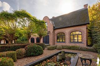 In de gegeerde wijk <strong>Schotenhof </strong>ligt deze unieke <strong>villa</strong>, omringd door groen, nabij scholen, sportclubs en op fietsafstand van twee dorpscentra.<br />De <strong>tuin </strong>ligt zonovergoten op het <strong>zuiden</strong>, zonder inkijk. De voortuin met haar gezellige waterpartij is riant, en kent een prachtig eiken <strong>bijgebouw</strong>, met verwarming en opbergplaats.<br /><br /><strong>INDELING</strong><br />Via enkele treden kom je via een zeer brede inkomdeur in een riante inkomhal. De dubbele glazen deur geeft meteen verbinding met de leefruimte, waar dezelfde mooie natuurstenen vloer doorloopt. Het verhoogde zitgedeelte kent een gezellige open haard. Voorts is er nog een eetgedeelte met toegang tot de keuken. Langs voor- en achterzijde voel je de verbinding met de groene tuin.<br />Aansluitend is de keuken met het hart van de woning, de AGA, en een gezellig eiland met eetgelegenheid. Miele ovens. Het houten werkblad dient opgefrist te worden. De glazen deurtoegang naar het terras en de tuin is heerlijk . Een bureau of polyvalente kamer met eveneens toegang tot het terras en vervolgens een praktische ruime bijkeuken. <br />De dubbele <strong>inpandige garage </strong>biedt niet alleen plaats voor twee auto’s, maar zorgt ook voor extra opbergruimte.<br /><br /><strong>Eerste verdieping</strong><br />De nachthal geeft toegang tot de hoofdslaapkamer, een badkamer en nog drie bijkomende slaapkamers met tal van ingemaakte kasten met een tweede badkamer.<br /><br />Een tweede trap biedt toegang tot een riante kamer met mezzanine en nog eens toegang tot een zolder. <br />Volop ruimte, nog in te delen naar believen.<br />Een kelder met bijzonder veel ruimte.<br /><br />De prachtig aangelegde tuin heeft een ideale <strong>zuid-oriëntatie</strong>, waardoor u hier vanaf de vroege ochtend tot laat in de middag volop van de zon geniet. Een waar paradijs in alle privacy en rust.<br /><br /><strong>Bijzonderheden</strong><br />* Toplocatie: Residentieel en groen gelegen in Schotenhof, vlakbij ’s Gravenwezel, én Schoten, diverse scholen én sportfaciliteiten met ondermeer gerenommeerde tennisclub.<br />* Ruimte & potentieel: Familiewoning met 5 slaapkamers en 2 badkamers.<br />* Buitenleven: Prachtig zonnige tuin met optimale privacy en riant eiken bijgebouw.<br />* Praktisch: Inpandige dubbele garage, én een extra garage én riante voortuin. Comfortabele bijkeuken en opbergzolder. <br /><br />Een unieke gelegenheid.