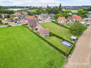<strong>Ligging:</strong><br />Deze alleenstaande villa is rustig gelegen in Sint-Eloois-Vijve, op slechts 5 minuten van het centrum van Waregem en vlakbij de belangrijkste invalswegen. De woning bevindt zich op een perceel van 911m², omringd door groen, en beschikt over een bewoonbare oppervlakte van 276m². Dankzij de ruime indeling, de aanwezigheid van een slaapkamer of bureau op het gelijkvloers en de vele bergruimtes is dit een woning met heel wat mogelijkheden.<br /><br /><strong><u>Indeling:</u></strong><br />Via de inkomhal kom je terecht in de ruime leefruimte met eetplaats en gezellige houthaard. Aansluitend bevindt zich de zeer ruime, geïnstalleerde keuken waar voldoende plaats is voor een ontbijthoek. Verder beschikt het gelijkvloers over een praktische wasberging, een ruime droge kelder, twee badkamers, een apart gastentoilet en een extra kamer die perfect kan dienen als slaapkamer, bureau of praktijkruimte.<br /><br />Vanuit zowel de leefruimte als de keuken is er rechtstreeks toegang tot het zuidgerichte terras. Op de verdieping bevinden zich drie ruime slaapkamers, een verder af te werken badkamer & dressing, en een polyvalente ruimte die naar eigen wens kan worden ingericht.<br /><br />Achteraan het perceel bevindt zich een vrijstaande garage van 40m² met een zolderverdieping, ideaal als garage, opslag- of hobbyruimte. Verder hebben we een ruime tuin, volledig omringd door groen en met veel privacy.<br /><br /><u><strong>Technisch:</strong></u><br />De elektrische installatie werd recent conform gekeurd. De woning beschikt over een EPC C, waardoor er geen renovatieverplichting van toepassing is. Verder is de woning ook uitgerust met centrale verwarming op mazout, rolluiken, deels elektrisch, en een regenwaterput van 10.000 liter met recent vernieuwde pomp.<br /><br /><u><strong>Grootste troeven:</strong></u>
<ul>
<li>Rustige ligging nabij Waregem</li>
<li>276m² bewoonbare oppervlakte</li>
<li>4 slaapkamers of bureau op het gelijkvloers</li>
<li>Vrijstaande garage van 40m²</li>
<li>EPC C (12 zonnepanelen en 2 thuisbatterijen)</li>
<li>Asbestveilig</li>
</ul>
<u><strong>Contact</strong></u><br />Meer info of een bezoek ter plaatse? Contacteer Cedrik op 0472 66 56 64 of via cedrik@real-immo.be.