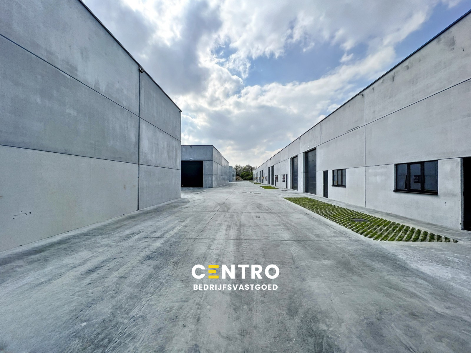 Kwalitatief en goed geïsoleerd NB MAGAZIJN (265m2), voorzien van elektrische sectionaalpoort, deur, raam (voor kantoor) en 2 private parkeerplaatsen op industriezone te Waregem. - photo 1