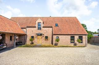 Luxueuze villa met paardenaccomodatie, in een groene, landelijke omgeving. Op een prachtige rustige locatie bevindt zich deze uitzonderlijke villa, opgetrokken in een stijlvolle landelijke architectuur en afgewerkt met hoogwaardige materialen. Deze eigendom combineert charme, comfort en kwaliteit en biedt een unieke woonbeleving voor wie houdt van ruimte, rust en een verfijnde levensstijl.Bij het betreden van de woning valt meteen de aandacht voor detail op. De natuurstenen vloeren, keukenbladen in hoogwaardige materialen en het volledig uitgevoerde binnenschrijnwerk in volle eik getuigen van een tijdloze elegantie. Het buitenschrijnwerk in tropisch hardhout onderstreept de duurzame en kwalitatieve afwerking van deze prachtige villa.De woning beschikt over ruime en lichtrijke leefruimtes, ideaal voor zowel dagelijks comfort als het ontvangen van gasten. Met 5 slaapkamers en 2 badkamers biedt de villa alle ruimte voor een gezin of wie extra kamers wenst voor kantoor, hobby of logies. Op het gelijkvloers bevindt zich een bijzonder comfortabele mastersuite met dressing en aansluitende badkamer.Buiten geniet u van een prachtig aangelegde tuin met sfeervolle waterpartij, die naadloos aansluit op de omliggende weide. De aanwezigheid van paarden- of ponystallingen maakt deze eigendom bijzonder aantrekkelijk voor paardenliefhebbers of wie droomt van een landelijke levensstijl.Daarnaast beschikt de woning over een ruime carport voor 3 wagens en tal van praktische voorzieningen.Een uitzonderlijke eigendom, perfect onderhouden tot in de kleinste details, waar kwaliteit, ruimte en landelijke charme harmonieus samenkomen.