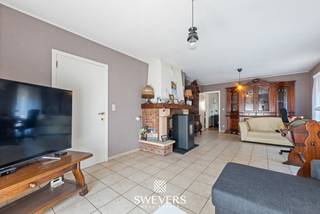 Voor meer info en foto’s, surf naar www.swevers.be – Op zoek naar een open bebouwing met een praktische indeling en uitbreidingsmogelijkheden? Dan is deze woning aan de Zangstraat 2 in Wellen zeker een bezoek waard. Deze gelijkvloerse woning uit 1979 biedt 144 m² bewoonbare oppervlakte op een perceel van 585 m². De lichtrijke leefruimte van 31 m² sluit aan op een ruime keuken van 16 m², die alle mogelijkheden biedt om een moderne leefkeuken te creëren. Verder zijn er drie volwaardige slaapkamers, een badkamer en een praktische berging.<br />Een grote troef is de volledige onderkeldering van 94 m. Ook de inpandige garage van 28 m² bevindt zich hier. Daarnaast beschikt de woning over een geïsoleerde zolder met uitbreidingspotentieel voor extra woonruimte.<br />De tuin met noordoostelijke oriëntatie biedt voldoende ruimte om een terras of gezinsvriendelijke tuin aan te leggen. Zonnepanelen, rolluiken en de geïsoleerde zolder zorgen bovendien voor extra comfort.<br />Ook de ligging is aantrekkelijk. Het centrum van Wellen ligt op minder dan 2 km, scholen op 1,5 km en ontspanningsmogelijkheden op ongeveer 1 km. Openbaar vervoer bevindt zich op slechts 150 meter en de snelwegen zijn vlot bereikbaar op ongeveer 12 km. Een woning met een solide basis, veel bergruimte en tal van mogelijkheden voor wie comfortabel gelijkvloers wil wonen. Voor meer informatie, bel 011 255 155. Bron bewoonbare oppervlakte: EPC – verslag.