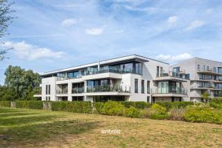 Dit hoogstaand afgewerkt appartement is gelegen in een private parktuin in Gentbrugge.<br /><br />Het appartement in kwestie heeft een netto oppervlakte van 90,14 m², een bijkomend Zuidwest-terras van 9 m² , vloerverwarming, een ventilatie systeem D, een super uitgeruste keuken met Miele toestellen, veel lichtinval en een mooi uitzicht richting de private parktuin.<br /><br />Indeling:<br />inkomhal met vestiairenis, toilet, grote leefruimte met open keuken (en berging), zonneterras met terrasberging, 2 mooie slaapkamers waarvan 1 met een grote dressing en een badkamer (dubbele lavabo en grote inloopdouche).<br /><br />Een ondergrondse autostaanplaats (PC21) dient mee gehuurd te worden aan 100 €/mnd (incl. gemeenschappelijke kosten).<br /><br />140 €/mnd gemeenschappelijke kosten, inclusief een voorschot op de privatieve verwarming.<br /><br />De bereikbaarheid is TOP door onder meer de ligging tov. het centrum van Stad Gent (slechts 11 min met de fiets tot aan het Gent-Zuidpark), de oprit van de E17, fietsafstand van het treinstation in Gentbrugge/Dampoort, ... hierdoor hebben we een mobiscore van 8,9/10<br /><br />Indien u meer info wenst of een bezoek ter plaatse, aarzel dan niet en neem gerust contact op met Pieterjan Windey op pw@entree.be of gsm 0472 80 20 65