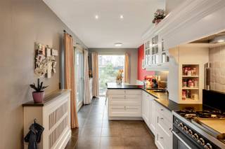 <p><span>Charmante & ruime woning met garage, kangoeroemogelijkheid en gezellige tuin in centrum Wijnegem! Over het park & op wandelafstand van het kanaal.</span></p><p><span> </span></p><p><span>In het hart van Wijnegem bevindt zich deze verrassend ruime en perfect onderhouden rijwoning met garage, gezellige tuin en tal van mogelijkheden. Dankzij de indeling en aparte woonunit op de eerste verdieping is dez woning ideaal voor kangoeroewonen, een inwonende ouder of verhuur.</span></p><p><span> </span></p><p><span>Bij het binnenkomen betreedt u een verzorgde inkomhal met vestiairekast en gastentoilet. </span></p><p><span>De gelijkvloerse verdieping biedt twee aangename leeftuimtes & eetkamer met ingbouwde kasten.</span></p><p><span>Een ruime & volledig uitgeruste leefkeuken, het echte hart van het huis. Hier vindt u een kwalitatief Boretti gasfornuis met teppanyaki-plaat en 2 ovens, een ingebouwde microgolf, een ruime Boretti koelkast, diepvries en wijnkast. De keuken is bovendien ingericht als echte leefruimte met een gezellige ingebouwde zitbank, vanwaar u een mooi zicht op de tuin heeft.</span></p><p><span> </span></p><p><span>Aansluitend bevindt zich een gezellige en volledig aangelegde tuin met overdekt terras, tuinhuis en wandelpadjes. De tuin is volledig omheind en vormt een ideale plek om in alle rust te genieten.</span></p><p><span> </span></p><p><span>Via de trap bereikt u de eerste verdieping, die momenteel ingericht is als een volwaardig appartement. Deze verdieping beschikt over een leefruimte met gezellige gashaard, keuken, slaapkamer, badkamer en apart toilet. Vanuit de slaapkamer heeft u toegang tot een ruim terras met zicht op het kanaal, wat de verdieping perfect maakt voor kangoeroewonen of een aparte woonunit.</span></p><p><span> </span></p><p><span>De tweede verdieping telt drie slaapkamers waarvan één bijzonder ruime kamer met inloopdressing. Verder is er een comfortabele badkamer met bad en douche, evenals apart toilet.</span></p><p><span> </span></p><p><span>Op de eerste en 2de verdieping is er airconditioning aanwezig.</span></p><p><span>Praktisch is ook de inpandige garage met aansluitende ruime berging, ideaal voor opslag of hobbyruimte.</span></p><p><span>Tevens een droge kelder aanwezig.</span></p><p><span> </span></p><p><span>De gevel van de woning werd recent aangepakt en voorzien van een waterafstotende gevelafwerking, wat bijdraagt aan het verzorgde en duurzame karakter van de woning.</span></p><p><span> </span></p><p><span>Kortom: een veelzijdige en instapklare woning met uitzonderlijk veel ruimte en mogelijkheden, gelegen op een centrale locatie in Wijnegem, dicht bij winkels, scholen en openbaar vervoer.</span></p><p><span>Woning is vergund als 2 woonunits!</span></p>