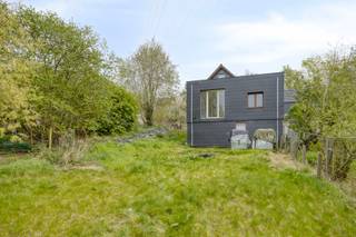 Op een unieke en uitzonderlijk rustige ligging in de Kruiskensheide 25 Lembeek bevindt zich deze instapklare woning, volledig omgeven door groen. De woning ligt in tweede bouwlijn, weg van de straat, en is enkel bereikbaar via een smalle doorgang voor voetgangers, fietsers en brommers (niet toegankelijk met de wagen – zie plan). Dit maakt het een ideale plek voor wie op zoek is naar pure rust en privacy.

De woning werd recent grondig gerenoveerd en beschikt over een nieuw dak, nieuwe ramen en vernieuwde elektriciteit, waardoor u zonder zorgen kan intrekken.

Bij het betreden komt u in de inkomhal die uitgeeft op een open en lichtrijke leefruimte. Aansluitend bevindt zich rechts een ruime, praktische keuken met handige zijdeur.

Aan de achterzijde van de woning geniet u van een prachtig, groen uitzicht. Hier bevinden zich:

een ruime slaapkamer
een comfortabele badkamer
een apart toilet

Op de verdieping treft u een grote overloop, ideaal als bureau, speelruimte of hobbykamer. Daarnaast zijn er twee ruime en lichtrijke slaapkamers aan weerszijden.

Extra troeven:

ruime bergkelder
aangesloten op riolering
mogelijkheid tot behalen van EPC-label B na installatie van een warmtepomp (momenteel verwarmd met houtkachel)

Deze woning is een unieke opportuniteit voor wie houdt van charme, ruimte en absolute rust, midden in het groen.
Meer info: Michael@immoaccenta.be