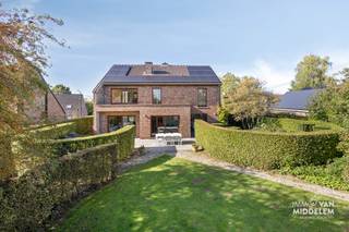 <strong>Immo Van Middelem biedt deze ruime villa aan in een rustige wijk te Lennik op een perceel van +/- 14a15. Een plek waar rust en groen de hoofdrol spelen, zonder in te boeten aan bereikbaarheid.<br /></strong><br />De woning onderscheidt zich door haar originele architectuur, speelse niveauverschillen en doordachte indeling. De verschillende leefruimtes zorgen voor een bijzondere ruimtebeleving en geven de villa een geheel eigen karakter.<br /><br />Een absolute blikvanger is de prachtige tuin, ontworpen en aangelegd door tuinarchitect Paul Beyl. De sierlijke vormen, zorgvuldig gekozen beplanting en verschillende groene hoekjes vormen samen een harmonieus geheel waar rust en privacy centraal staan.<br /><br />De indeling is als volgt:<br />- GELIJKVLOERS: inkomhal met vestiaire, gastentoilet, toegang tot de garage, lichtrijke woonkamer en eethoek met toegang tot het terras en de tuin, open keuken met ontbijthoek en toegang tot het terras en wasplaats; <br />- dubbele GARAGE;<br />- 1ste NIVEAU: 2 ruime slaapkamers, 1 apart WC;<br />- 2de NIVEAU: 2 ruime slaapkamers waarvan 1 met toegang tot het zonneterras, badkamer met douche, bad en dubbele lavabo;<br />- KELDERVERDIEPING: de woning is deels onderkelderd en onderverdeeld in een technische ruimte en 2 kelders.<br /><br />Solide betonnen structuur.<br />EPC: 162Kwh/m².jaar - Label B (UC:3955670).<br />Elektrische installatie CONFORM AREI tot 2042.<br />22 zonnepanelen met 7590Wp..<br />Vrij vanaf 01/07/2027.