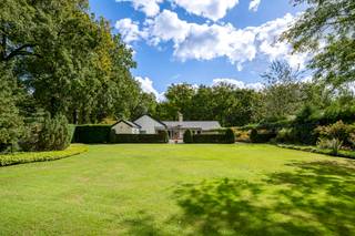 <strong>Charmante gelijkvloerse villa op ca. 3.660 m² in groene parkomgeving!</strong><br /><br /><strong>Comfort, privacy en een uitstekende indeling met een idyllische ligging in een prachtig aangelegde parktuin. Dankzij de vele raampartijen en de doordachte inrichting straalt elke ruimte licht en warmte uit.</strong><br /><br /><strong>De gelijkvloerse verdieping:</strong><br />- <strong>Inkomhal </strong>met gastentoilet en handenwasser, en glazen deur die toegang geeft tot de leefruimte<br />- <strong>Woonkamer </strong>met overvloedig <strong>lichtinval </strong>door de vele <strong>raampartijen</strong>, een <strong>gashaard </strong>voor extra gezelligheid en twee aansluitende deuren naar het terras<br />- <strong>Keuken </strong>uitgerust met dubbele lavabo, Siemens vaatwasser, gasvuur, ATAG oven en microgolf, ingebouwde koelkast en een gezellige <strong>ontbijthoek </strong>met <strong>coffeecorner</strong><br />- <strong>Bijkeuken </strong>met extra lavabo, aansluiting voor wasapparatuur en rechtstreekse toegang tot de <strong>carport (tweede ingang)</strong><br />- <strong>Hoofd</strong><strong>vleugel </strong>met royale <strong>slaapkamer </strong>op vast tapijt, <strong>dressing</strong>, praktische <strong>berging </strong>en aansluitende <strong>badkamer </strong>met dubbele lavabo, <strong>inloopdouche </strong>en toilet. Vanuit zowel de slaapkamer als de badkamer directe toegang tot terras en tuin<br />- <strong>Slaapvleugel </strong>aan de andere zijde met nachthal op vast tapijt, <strong>twee </strong>bijkomende <strong>slaapkamers </strong>en een <strong>tweede badkamer</strong> voorzien van ligbad, lavabo en toilet<br /><br /><strong>Tuin &amp; terras:</strong><br />- Het <strong>terras </strong>is verlenging van de leefruimte, <strong>deels overdekt </strong>en voorzien van een <strong>verwarmd buitenzwembad</strong><br />- <strong>Buitenkitchenette </strong>met ingemaakte kasten, lavabo, koelkast <br />- <strong>Buitendouche </strong>en <strong>praktische bergruimte</strong>: een technische berging voor de zwembadinstallatie en een aparte tuinberging met toegang tot de oprit<br />- <strong>Volledig omheind en privatieve NW-tuin</strong>, met als eyecatcher een majestueuze <strong>Treurcipres </strong>centraal in het groen<br /><br /><strong>Algemeen</strong><br />- Verwarming op gas met radiatoren en heteluchtroosters<br />- <strong>Uitstekend onderhouden </strong>doorheen de jarenn<br />- Voorzien van <strong>40 zonnepanelen</strong><br />- Lange privatieve <strong>oprijlaan </strong>met <strong>automatische poort</strong> en <strong>dubbele carport</strong><br />- <strong>Rustige ligging, omgeven door natuur en parktuin</strong><br />- <strong>Doordachte indeling </strong>met een vlotte circulatie tussen de ruimtes<br /><strong>- Volledig nieuw dak in 2021</strong><br />- Extra troef: mogelijkheid tot <strong>praktijk </strong>aan huis