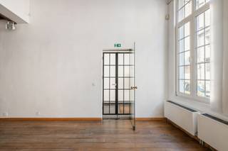 Situé dans la Keizerstraat, au cœur historique d’Anvers, ce rez-de-chaussée commercial de caractère offre une superficie d’environ 150 m². Sa situation centrale, combinée à son accessibilité aisée par les Leien et les transports en commun à proximité, constitue un atout majeur.
L’espace se distingue par son caractère authentique et son agencement ouvert. La façade imposante et les grandes baies vitrées lui confèrent une allure attrayante ainsi qu’une agréable luminosité naturelle. À l’intérieur, le plancher en bois et la structure apparente des poutres créent une atmosphère chaleureuse et pleine de caractère.
Grâce à son plan rectangulaire bien structuré, le bien offre diverses possibilités d’aménagement et d’utilisation. Il convient notamment pour un bureau, un espace de pratique professionnelle, une profession libérale, une galerie ou toute autre activité commerciale.
Un atout supplémentaire réside dans le sous-sol, agrémenté de voûtes en briques authentiques et d’un sol carrelé. Cet espace de caractère peut être utilisé de manière flexible comme espace de stockage, salle de réunion ou espace professionnel ou de travail supplémentaire.
Un sanitaire et une kitchenette sont présents. D’éventuels aménagements du bien peuvent être discutés avec le propriétaire, en fonction de l’affectation envisagée.
La provision mensuelle pour l’eau, le gaz et le précompte immobilier s’élève à 275 €. L’électricité doit être souscrite séparément et individuellement par le locataire.