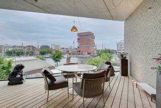 <p>Op een absolute toplocatie aan de Napoleonkaai bevindt zich dit uitzonderlijke appartement, gelegen in een prestigieus gebouw uit 2011. Met zijn royale volumes, hoogwaardige afwerking, meerdere terrassen en spectaculaire zichten op het MAS, het Willemdok en het Verbindingsdok biedt deze eigendom een unieke woonervaring in het hart van het Antwerpse Eilandje.</p>
<p>Bij het betreden van het appartement komt u binnen via een gepantserde veiligheidsdeur in een stijlvolle inkomhal. Via een grote glazen deur bereikt u de indrukwekkende leefruimte, waar licht, ruimte en comfort centraal staan. Dankzij een gevelbreedte van maar liefst 14 meter, plafondhoogtes van circa 3 meter en grote raampartijen geniet u hier van een uitzonderlijke natuurlijke lichtinval en een prachtig zicht op het water.</p>
<p>De leefruimte werd afgewerkt met een kwalitatieve parketvloer, maatwerkkasten, surround muziekinstallatie en een sfeervolle ingebouwde gashaard. Aansluitend bevindt zich hier een eerste terras van ca 8 m² dat tevens ook toegankelijk is vanuit de masterbedroom.</p>
<p>De luxueuze open keuken werd uitgerust met hoogwaardige Miele-toestellen en biedt alles wat de veeleisende hobbykok zich kan wensen. Zo beschikt de keuken over een wijnkoeler, koelkast, diepvriezer, inductiekookplaat, dubbele spoelbak, stoomoven, combi-oven, traditionele oven, warmhoudlade en ingebouwde koffiemachine. Aansluitend bevindt zich een praktische bijkeuken met extra bergruimte. Aansluitend bevindt zich een royaal terras van ca. 13 m², waar u volop kunt genieten van de avondzon en de unieke vergezichten over het MAS, het Verbindingsdok en het Willemdok.</p>
<p>Via de nachthal, voorzien van maatwerkkasten en een gastentoilet, bereikt u het slaapgedeelte. De royale master bedroom van ca. 23<strong> </strong>m² beschikt over een ruime ensuite dressing en een luxueuze badkamer. Deze badkamer is uitgerust met een vrijstaand designbad, een ruime inloopdouche, dubbele lavabo en toilet. Vanuit de badkamer en slaapkamer geniet u bovendien van een uniek zicht op het tweede terras.</p>
<p>Verder beschikt het appartement momenteel over een zeer ruime tweede kamer die vandaag is ingericht als combinatie van bureau en slaapkamer met aansluitende badkamer voorzien van douche, toilet en lavabo. Volgens het oorspronkelijke plan kan deze ruimte eenvoudig opnieuw worden opgesplitst in twee volwaardige slaapkamers. De kamers kijken uit op de rustige binnentuin van het gebouw en beschikken over een dressing.</p>
<p>Ook praktisch comfort werd niet vergeten. Het appartement beschikt over airco, vloerverwarming, plafondhoge blokdeuren, een afzonderlijke wasruimte met ingebouwde kasten en een privatieve kelderberging.</p>
<p>Er is een dubbele garagebox op niveau -3 aan te kopen voor €100.000, een bijzonder waardevolle troef op deze locatie.</p>
<p>Extra troeven:<br />✔ Panoramische zichten op MAS, Willemdok en Verbindingsdok<br />✔ Twee ruime terrassen met optimale oriëntatie<br />✔ Hoogwaardige Miele-keuken met volledig toestellenpakket<br />✔ Parketvloer, vloerverwarming en airconditioning<br />✔ Ingebouwde gashaard en maatwerkkasten<br />✔ Master suite met dressing en luxebadkamer<br />✔ Mogelijkheid tot 3 slaapkamers<br />✔ Dubbele garagebox (€100.000)<br />✔ Privatieve kelderberging</p>
<p>Een uitzonderlijk appartement voor wie op zoek is naar ruimte, luxe, comfort en unieke zichten op één van de meest gegeerde locaties van Antwerpen.</p>
<p>Voor meer informatie of een bezoek ter plaatse kan u contact opnemen met Vincent via 0475/21.00.86 vincent@reds.be</p>