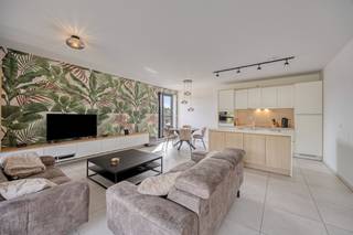 Gelegen in het gezellige Bevingen, op een steenworp van Sint-Truiden en met een uitstekende verbinding naar de rest van de regio, biedt dit gloednieuwe appartement alles wat je van een moderne en energiezuinige woning mag verwachten.<br /><br />Het appartement van circa 90 m² werd gebouwd en voor het eerst bewoond in 2025 en beantwoordt aan alle energienormen met een E-peil van slechts 10, zonnepanelen, vloerverwarming en koeling en een ventilatiesysteem type D.<br /><br />De indeling is doordacht en comfortabel. Via de inkomhal met vestiairekasten bereik je de lichtrijke leefruimte die via een grote raampartij aansluit op het ruime overdekte terras met daarachter de privé tuin. De volledig uitgeruste keuken grenst aan een praktische berging. Via de nachthal ga je naar een apart toilet, een knap ingerichte badkamer met inloopdouche en lavabo, en twee aangename slaapkamers.<br /><br />Wat dit appartement echt onderscheidt, is de buitenruimte. De volledig omheinde privétuin van maar liefst 135 m², het ruime overdekte terras en de grote gemeenschappelijke parktuin achteraan zorgen ervoor dat je heerlijk kan genieten. Daarnaast beschik je over niet één, maar twee ondergrondse autostaanplaatsen en een kelderberging voor extra opslagruimte.<br /><br />Je kan hier een praktisch nieuwbouwappartement kopen aan het verlaagde registratierecht van 2% indien je aan de voorwaarden voldoet.<br /><br />Troeven in een oogopslag:<br /><br />✔ Nieuwbouw 2025, instapklaar<br />✔ E-peil 10, zonnepanelen, vloerverwarming, ventilatie D<br />✔ Privétuin van 135 m²<br />✔ Groot overdekt terras<br />✔ Twee ondergrondse parkeerplaatsen<br />✔ Kelderberging<br />✔ Gemeenschappelijke tuin en fietsenstalling<br />✔ Centrale ligging in Bevingen met vlotte verbinding naar Sint-Truiden<br />✔ Te koop aan registratierechten<br /><br />Is je interesse gewekt? Neem snel contact op voor een bezoek ter plaatse!