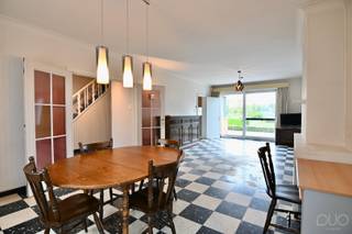 Deze ruime gezinswoning is gelegen aan de Vliegveldlaan in Brustem, op een prachtig perceel van maar liefst 14a89ca. De woning geniet achteraan van een weids en groen uitzicht over de achterliggende weilanden, waardoor u hier volop kunt genieten van rust en ruimte. Dankzij de ligging nabij de N3 bereikt u vlot zowel het centrum van Sint-Truiden als de richting Luik. Ook de verbindingsweg naar de N80 bevindt zich vlakbij. Het openbaar vervoer vindt u op amper 250 meter van de woning.<br /><br />We betreden de woning via een ruime inkomhal met apart gastentoilet. Deze centrale inkomhal vormt het hart van de woning en biedt toegang tot de verschillende leefruimtes, de bovenverdieping en de praktijkruimte. De ruime woonkamer is aangenaam licht dankzij het grote schuifraam dat een mooie verbinding vormt met het terras en de tuin. De leefruimte biedt plaats aan een gezellige zithoek en een eetruimte. Aansluitend vinden we de ingerichte keuken met praktische ontbijthoek. De wasplaats/berging vormt de verbinding tussen de keuken en de praktijkruimte aan de achterzijde van de woning. Zowel de keuken als de praktijkruimte genieten van een aangenaam zicht op de tuin.<br /><br />Een absolute troef van deze woning is de ruime praktijkruimte met een aparte ingang aan de voorzijde van de woning en een aparte parkeerplaats. Via deze toegang komt men in een wachtruimte met balie, waarna twee polyvalente kamers toegankelijk zijn. Deze ruimtes vloeien mooi in elkaar over en kunnen volledig worden ingericht volgens de behoeften van de nieuwe eigenaar. Dankzij de aparte toegang is deze ruimte bijzonder geschikt voor een zelfstandige activiteit, vrij beroep of praktijk, maar uiteraard kan ze ook dienstdoen als bureau, hobbyruimte, speelruimte of extra leefruimte.<br /><br />Op de bovenverdieping bevinden zich de nachthal, badkamer en vier ruime slaapkamers. Daarnaast beschikt de woning over een ruime zolderverdieping die nog tal van mogelijkheden biedt. Mits de nodige afwerking kan deze perfect worden ingericht als vijfde slaapkamer of extra leefruimte. Wie geen bijkomende woonruimte nodig heeft, kan de zolder uiteraard ook gebruiken als bijzonder praktische stockageruimte.<br /><br />De volledige woning beschikt over een kelder, gedeeltelijk uitgevoerd als kruipkelder, wat zorgt voor extra bergruimte en praktische mogelijkheden.<br /><br />Ook buiten heeft deze woning heel wat te bieden. Het ruime terras sluit mooi aan bij de leefruimtes en vormt samen met de aangelegde tuin een aangename plek om te ontspannen en te genieten van het open uitzicht over de weilanden. Verder beschikt de woning over een dubbele carport met praktische opbergmogelijkheden voor fietsen, tuinmateriaal en allerhande benodigdheden.<br /><br />Deze woning is dan ook een bijzonder interessante opportuniteit voor wie op zoek is naar een ruime gezinswoning met vier slaapkamers, een zolder met uitbreidingsmogelijkheden en een volwaardige praktijkruimte met afzonderlijke toegang. De combinatie van de royale perceeloppervlakte, het prachtige groene uitzicht, de vele mogelijkheden en de vlotte bereikbaarheid maakt van deze woning een uniek geheel.<br /><br />Bent u op zoek naar een ruime gezinswoning waar wonen en werken perfect gecombineerd kunnen worden, of wenst u gewoon te genieten van veel ruimte en mogelijkheden op een mooi perceel? Maak dan snel een afspraak voor een bezoek via 011 70 70 19.<br />