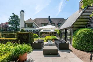 Unieke villa met binnenzwembad, vijver, polyvalente ruimte en garage op 15.399m² te Lier/Koningshooikt. <br /><br />Algemeen:<br />- Mooie villa met binnenzwembad<br />- Gelegen op een prachtig perceel van 15.399 m²<br />- Achtergelegen polyvalente ruimte (ca. 315m²)<br />- Achtergelegen garage/magazijn met aparte ingang (ca. 611 m²)<br />- Conciërgewoning (ca. 105m²) boven polyvalente ruimte<br />- Grote vijver<br />- Woning is deels verbouwd in 2006<br />- Keuken vernieuwd in 2021<br />- Nieuw dak op bijgebouw in 2024<br />- Top EPC score: 120 kWh/m²/jaar (label B)<br />- 102 zonnepanelen op het magazijn<br />- Prachtige orangerie met bbq/haard<br /><br />Indeling:<br />De kwalitatieve villa gelegen met grote leefruimte, eetkamer, keuken, binnenzwembad, bar, sauna, grote tuinkamer/orangerie,... Deze villa beschikt over een mooi aangelegde tuin met grote vijver. Op de eerste verdieping van de woning zijn 5 slaapkamers en 3 badkamers gelegen. In de slaapkamers is bovendien ook airco aanwezig. <br /><br />Daarnaast is er een verbinding op het gelijkvloers tussen de woning en de polyvalente ruimte en het magazijn. Momenteel is het eerste deel ingericht als feestzaal met een bar en verschillende bergingen + garage. De feestzaal heeft een prachtig zicht op de vijver. Achteraan is een groot magazijn aanwezig, deze is toegankelijk via een poort en een aparte in- en uitrit aan de straatkant.<br />Boven de polyvalente ruimte is een conciërgewoning van ca. 105 m² met 2 slk, badkamer, leefruimte met open keuken en terrasje.<br /><br />Voor de exacte indeling bekijk de plannen op onze website.