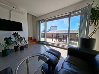 Unieke duplex doorzon penthouse naast Park Spoor Noord met uitzonderlijk terras (90 m²) &amp; gemeenschappelijke binnentuin – optionele garagebox &amp; berging<br /><br />Op een toplocatie aan Park Spoor Noord in Antwerpen bevindt zich deze stijlvolle duplex penthouse (3 gevels) van ca. 120 m² met een uitzonderlijk terras van maar liefst 90 m² rondom de leefruimte.<br /><br />Dankzij de hoekligging geniet het terras de hele dag van de zon, volledige privacy en een open uitzicht over de stad en de haven.<br /><br />De lichtrijke leefruimte met grote raampartijen sluit naadloos aan op de eetruimte en vormt een ruim open geheel. De indrukwekkende Bulthaup designkeuken met videhoogte van ca. 6 meter is uitgerust met hoogwaardige toestellen en biedt veel opbergruimte.<br /><br />Via een elegante massieve eiken trap bereikt u de bovenverdieping met twee comfortabele slaapkamers, beide voorzien van veluxramen met zonwering en ingebouwde kasten. De badkamer werd vernieuwd en beschikt over een ruime inloopdouche met regendouche.<br /><br />Grote gemeenschappelijke binnentuin voor bewoners biedt groen en ontspanning.<br /><br />Extra comfort wordt geboden door Daikin airconditioning, zonwering en een recente Buderus condensatieketel.<br /><br />Troeven<br />•Duplex penthouse ca. 120 m²<br />•Terras ca. 90 m² rondom leefruimte<br />•Hoekligging met zon gedurende de hele dag<br />•Bulthaup designkeuken met premium toestellen<br />•Videhoogte keuken ±6 m<br />•2 slaapkamers met ingebouwde kasten<br />•Vernieuwde badkamer<br />•Airconditioning (Daikin)<br />•Grote gemeenschappelijke binnentuin<br />•Uitzicht over Antwerpen en de haven<br /><br />Optioneel 50.000 €<br />•Hörmann garagebox met motor &amp; afstandsbediening<br />•Afzonderlijke kelderberging<br /><br />Een zeldzame kans voor wie op zoek is naar een ruim, lichtrijk penthouse met uitzonderlijk terras op toplocatie.<br />