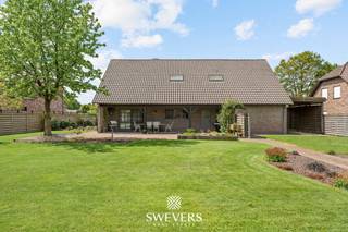 Voor meer info en foto’s, surf naar www.swevers.be – Deze ruime open bebouwing in een rustige straat in Hechtel-Eksel biedt maar liefst 282 m² bewoonbare oppervlakte op een perceel van 14a 15ca. De woning uit 1992 combineert veel leefruimte met een praktische indeling en werd recent opgewaardeerd met onder andere een nieuwe stookolieketel, zonnepanelen, vernieuwde garagepoort en Siemens-toestellen in de keuken. Op het gelijkvloers vindt u een lichtrijke woonkamer van 38 m² met airco, een ruime keuken van 20 m² met toegang tot het terras, een eerste slaapkamer van ca. 16 m², een berging en een apart gastentoilet. De inpandige dubbele garage van 48 m² biedt plaats voor twee wagens en extra stockage. De eerste verdieping telt vier bijkomende slaapkamers, waaronder twee zeer ruime kamers van ca. 32 m² en 28 m². Eén slaapkamer beschikt over airco. De badkamer is uitgerust met een ligbad, dubbele wastafel en toilet, aangevuld met een tweede inloopdouche. Daarnaast is er een ruime kelder van 61 m² en veel zolderruimte voor extra opslag. Buiten geniet u van een groot perceel met een terras van ca. 30 m² en een verzorgde tuin met veel mogelijkheden. Scholen, winkels, openbaar vervoer en ontspanning liggen vlakbij. Ook Nationaal Park Bosland en “Fietsen door de Bomen” bevinden zich in de omgeving. Voor meer informatie, bel 011 255 155. Bron bewoonbare oppervlakte: EPC – verslag.