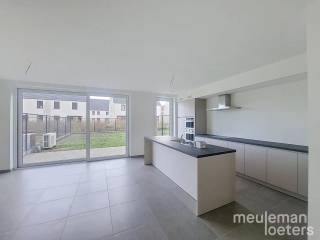 Cette maison moderne et économe en énergie est située dans un nouveau lotissement à Hertsberge. Il s'agit de la maison mitoyenne à gauche. Le lotissement a été réalisé en 2025-2026 et est équipé des techniques les plus récentes offrant un confort de vie contemporain.<br /><br />Au rez-de-chaussée, vous trouverez un hall d'entrée avec toilettes pour invités et lavabo, suivi d'un lumineux espace de vie avec une cuisine ouverte entièrement équipée. La cuisine comprend une plaque à induction, une hotte, deux éviers (grand et petit), un lave-vaisselle intégré, un four à convection et un grand réfrigérateur encastré. <br />À côté de la cuisine se trouve une buanderie spacieuse et fonctionnelle donnant accès à l'avant de la maison.<br /><br />Au premier étage, on trouve un hall de nuit, un WC séparé, trois chambres doubles ainsi qu'une chambre simple, une salle de bain entièrement équipée avec douche à l’italienne, baignoire et double lavabo. Un espace de rangement est également prévu à cet étage.<br /><br />Le salon et la cuisine donnent directement accès au jardin et à la terrasse. Le jardin sera aménagé avec une pelouse et un abri de jardin extérieur.<br /><br />La maison est également équipée de panneaux solaires, du chauffage par le sol et d’une allée privée. <br />La peinture est terminée en finition et des rails pour rideaux ont été installés.<br /><br />Pour une visite, vous pouvez réserver un créneau horaire via notre site web meuleman-loeters.be.