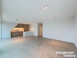 Dans le centre de Veldegem se trouve ce bel appartement avec deux chambres à coucher.<br /><br />Le hall d'entrée mène au séjour, où de grandes fenêtres constituent un atout majeur. De plus, les fenêtres sont équipées de stores électriques. La cuisine attenante est entièrement équipée avec des appareils SMEG, comprenant un lave-vaisselle, une plaque à induction avec hotte intégrée, un combiné réfrigérateur-congélateur et un four à chaleur tournante. À côté de la cuisine, une buanderie pratique dispose des raccordements pour une machine à laver et un sèche-linge.<br /><br />L'appartement comprend deux chambres, dont une avec une garde-robe intégrée. La salle de bain séparée est équipée d'une douche à l'italienne, d'un double lavabo, d'un meuble mural et d'un radiateur porte-serviettes.<br /><br />Grâce à sa situation au dernier étage, vous profitez d'une vue particulièrement belle depuis la grande terrasse.<br /><br />Le garage est inclus dans le prix de location et est doté d'une porte automatique, d'un éclairage et de l'électricité. Une station de recharge pour véhicules électriques peut également y être installée. Une deuxième place de garage peut être louée en option pour 75 € par mois. Les vélos peuvent être rangés en toute sécurité dans le local à vélos commun.<br /><br />L'appartement est déjà équipé de l'éclairage et de rails pour rideaux.<br /><br />Si vous souhaitez visiter ce bien, vous pouvez facilement réserver un rendez-vous via notre site web meuleman-loeters.be.