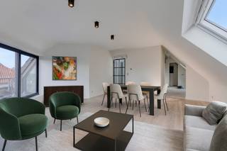 In het hart van het charmante Zeveneken, aan Hoekstraat 1, komt zelden zo'n kans voorbij. In een kleinschalig en kwalitatief project wordt dit prachtig afgewerkte dakappartement op de derde verdieping te koop aangeboden. Elk detail ademt klasse, comfort en verfijning. Wie hier binnenstapt, voelt het meteen: dit is thuiskomen.<br />De inkomhal leidt je naar de verschillende ruimtes, elk met hun eigen karakter. Via een elegante stalen deur kom je in de lichtrijke leefruimte op de hoek van het gebouw, waar een groot schuifraam zorgt voor overvloedig daglicht. Van hieruit heb je toegang tot het ruime terras – een heerlijke plek om buiten te genieten van het open zicht op de winkels en het kerkje van Zeveneken.<br />De open keuken vormt het hart van de leefruimte: stijlvol en praktisch tegelijk. Ze is uitgerust met een combi-oven, microgolf, vaatwasser en voldoende werkruimte om met plezier te koken. Aansluitend bevindt zich een handige berging, perfect voor extra opslag.<br />De stijlvolle badkamer is een oase van rust, voorzien van een moderne inloopdouche, een elegant lavabomeubel en een toilet. Daarnaast zijn er twee gezellige slaapkamers, ideaal als master bedroom en logeerkamer of bureau. Moderne technieken, zoals verwarming én koeling via een energiezuinige warmtepomp, zorgen voor optimaal wooncomfort.<br />Met een EPC-label A, een blanco elektriciteitsattest en hoogwaardige materialen is dit appartement niet alleen een ideale woonst, maar ook een goede investering. Op het gelijkvloers is er een gemeenschappelijke vuilnisberging en een afgesloten fietsenstalling. Recht tegenover het gebouw zijn er openbare parkeerplaatsen, en bovendien is er de mogelijkheid om een garage te huren of aan te kopen.<br />De ligging is perfect: op wandelafstand van winkels, apotheek, school en horeca, en uiterst centraal tussen Gent en Antwerpen, vlak bij de oprit van de E17.<br />Een stijlvol appartement, een doordacht ontwerp en een toplocatie – dit is wonen met klasse in Zeveneken.<br />Interesse? Neem vandaag nog contact op voor een bezoek en ontdek het zelf. Gsm 0496 299200.