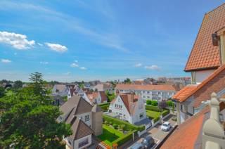 Stijlvol duplexappartement met zonnige terrassen en open zicht op de villa’s van het Zoute.<br />Lichtrijk en perfect onderhouden duplexappartement, gelegen in een stijlvolle en karaktervolle residentie in Normandische stijl. Het appartement biedt een schitterend open uitzicht op de omliggende Zoute-villa’s en geniet van een uiterst centrale ligging op wandelafstand van zowel het winkelcentrum als de zee.<br />Indeling:<br />Inkomhal met gastentoilet en vestiaire. Gezellige, lichtrijke leefruimte met open haard en ingemaakte kasten, waarvan één ingericht als bar. De woonkamer geeft uit op het ruime zonneterras aan de voorzijde, uitgerust met bergingen en een zonneluifel. Vanuit het salon geniet u van een prachtig panoramisch zicht. Aparte bergingen, waarvan één voorzien voor wasmachine.<br />Halfopen keuken met aangrenzende eethoek, uitgevend op het tweede terras achteraan voorzien van berging. <br />Verdieping:<br />Masterbedroom met ingemaakte kasten en en suite douchekamer. Tweede volwaardige slaapkamer eveneens met ingemaakte kasten. Aparte badkamer.<br />Privatieve kelder en gemeenschappelijke fietsenberging in de residentie.<br />Mogelijkheid tot aankoop van een staanplaats en/of garagebox in het gebouw.