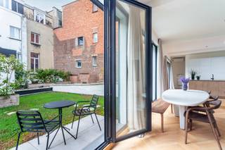 <p>Op zoek naar een karaktervolle loft in een uniek gebouw?<br />Dan is deze parel beslist iets voor u.<br /><br />De Begijnenvest verbindt ’t Zuid met de Theaterbuurt: zonder twijfel twee van de meest trendy en bruisende buurten van Antwerpen, waar cultuur, gastronomie en stadsleven centraal staan.</p>
<p>In 2023 onderging dit voormalige pakhuis een volledige renovatie, waarbij moderne comfort en historische charme naadloos werden gecombineerd. Via de private inkomhal leidt een trap naar de eerste verdieping, waar de royale loft zich ontvouwt met een indrukwekkende openheid en een hoogwaardige afwerking die zowel stijl als comfort uitstraalt.</p>
<p>De ruime leefruimte baadt in natuurlijk licht dankzij de grote raampartijen, wat een warme en uitnodigende sfeer creëert. De elegante parketvloer geeft een tijdloos karakter en benadrukt de hoogwaardige afwerking. De royale open keuken, uitgerust met een kookeiland en kwalitatieve inbouwtoestellen, combineert functionaliteit met stijl en nodigt uit tot comfortabel koken. Vanuit de keuken en de leefruimte geniet u van een prachtig uitzicht op het ruime terras en het groene dak, wat de verbinding met de buitenruimte extra versterkt. Een echte blikvanger is de halfopen slaapkamer met smeedijzeren deuren, die een charmante en karaktervolle toets toevoegt. Daarnaast beschikt de woning over een ruime badkamer met dubbele lavabo en inloopdouche, waardoor comfort en luxe perfect samenkomen.</p>
<p>Tot slot heeft u de mogelijkheid om een garagebox en staanplaats bij aan te kopen.</p>
<p>Interesse? Contacteer LISTED: +32 283 51 51</p>