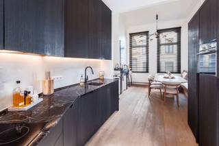 <p>Deze charmante en volledig afgewerkte herenwoning combineert authentieke elementen met hedendaags comfort en hoogwaardige afwerking. De woning werd de voorbije jaren smaakvol geüpdatet en is volledig instapklaar. Gelegen in het geliefde Oud-Berchem, op wandelafstand van het Albertpark en de iconische Brouwerij De Koninck, geniet u hier van een levendige buurt met tal van voorzieningen en een uitstekende bereikbaarheid.</p>
<p>Bij het binnenkomen wordt u verwelkomd in een statige inkomhal met een prachtige marmeren trap, die meteen de authentieke charme van het pand benadrukt. Vanuit de hal bereikt u het ruime souterrain, momenteel ingericht als bureau- en ontspanningsruimte met extra bergruimte. Dankzij de veelzijdige indeling kan deze verdieping eenvoudig worden aangepast aan uw woonbehoeften. Achteraan bevinden zich de praktische wasplaats en kelder.</p>
<p>De leefkeuken vormt het hart van de woning en werd stijlvol ingericht met een marmeren werkblad en kwalitatieve inbouwtoestellen. Aansluitend bevindt zich de eetruimte met een op maat gemaakte zitbank, die uitnodigt tot sfeervolle diners. De directe toegang tot de gezellige koer zorgt voor een aangename verbinding tussen binnen en buiten.</p>
<p>Een verdieping hoger vindt u een ruime en lichtrijke woonkamer met extra zithoek. Authentieke details, zoals de originele schouwmantel en de doorlopende parketvloer, creëren een warme uitstraling.</p>
<p>Op de bovenste verdieping bevindt zich de royale master bedroom met aansluitend een stijlvolle badkamer, uitgerust met een ligbad en een ruime inloopdouche. Een ideale plek om volledig tot rust te komen.</p>
<p>Extra troeven:</p>
<ul>
<li>Zonnepanelen</li>
<li>Airco in de volledige woning</li>
<li>Ingemaakte kasten</li>
<li>Mogelijkheid tot overname huurcontract van parking met laadpaal</li>
</ul>
<p>Een unieke woning voor wie op zoek is naar karakter, comfort en een toplocatie in Berchem.</p>
<p>Contacteer LISTED voor een bezoek: +32 3 283 51 51.</p>