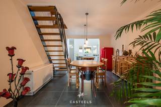 In een rustige straat in het bruisende Gent bevindt zich deze charmante, volledig gerenoveerde gemeenschapswoning met een privatief karakter en gedeelde voorzieningen.<br /><br />Een woning met karakter en potentieel<br /><br />De woning werd in 2021 volledig gerenoveerd en straalt vandaag kwaliteit en comfort uit. Ze beschikt over een lichte leefruimte met open keuken, waar een nieuwe Velux zorgt voor natuurlijke lichtinval en een aangename sfeer. De leefruimte staat rechtstreeks in verbinding met een privatief terras, ideaal om van het zonnetje te genieten.<br /><br />De woning heeft momenteel twee slaapkamers, waarvan één ingericht is als grote opbergruimte op de tweede verdieping. Deze ruimte biedt de mogelijkheid om er een zeer ruime slaapkamer van te maken of ze op te splitsen in twee aparte kamers, afhankelijk van uw noden. Bovenaan is er nog een zolderruimte, perfect als opslagruimte.<br /><br /><u><strong>Indeling van de woning</strong></u><br />• Gelijkvloers: lichtrijke leefruimte met open keuken, toegang tot privatief terras<br />• 1e verdieping: master bedroom, moderne badkamer met inloopdouche en dubbele lavabo<br />• 2e verdieping: grote open ruimte met potentieel voor extra slaapkamer(s)<br />• Zolder: handige opbergruimte<br /><br /><u><strong>Gemeenschappelijke troeven</strong></u><br /><br />Via een gemeenschappelijke poort bereik je de woninggemeenschap, die deel uitmaakt van een groter woonerf. Je geniet van een gemeenschappelijke stadstuin, gedeeld met andere bewoners, waar verbondenheid en privacy hand in hand gaan.<br />• Geen syndicus, maar wel een kleinschalige gemeenschap<br /><br /><strong><u>Troeven van deze woning</u></strong><br />• Volledige renovatie in 2021<br />• Instapklaar en modern afgewerkt<br />• Bewoonbare oppervlakte: 115 m²<br />• 2 ruime slaapkamers<br />• Mogelijkheid tot extra kamers op de 2e verdieping<br />• Extra zolderruimte voor opslag<br />• Uitgeruste badkamer met inloopdouche en dubbele badkamer<br />• Privaat terras<br />• Gedeelde tuin<br />• Perfect voor starters, koppels, gezinnen of investeerders<br /><br />Deze woning biedt een uitstekende combinatie van wooncomfort, ruimte en toekomstgerichte mogelijkheden.<br />Interesse? Contacteer ons en ontdek zelf het potentieel van dit pand!