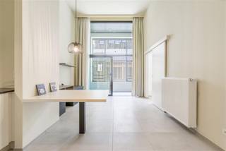 Deze erkende assistentiewoning is gelegen in het centrum van Kortrijk op amper 350 meter van de Grote Markt en op 1 minuut wandelen van het Shoppingcenter K. <br />Dankzij de onmiddellijke nabijheid van het bus- en treinstation en de belangrijkste invalswegen, is de bereikbaarheid voor u en uw bezoek optimaal. Bij het binnenkomen van de assistentiewoning is de keuze voor kwaliteit onmiddelijk merkbaar en de hoge plafonds geven een gevoel van ruimte.<br /><br />Bij binnenkomst treft u een inkomhal met ingemaakte vestiaire. De lichtrijke leefruimte sluit naadloos aan op de volledig geïnstalleerde open keuken, uitgerust met een inductiekookplaat, microgolfoven, koelkast met vriesvak, dampkap, Franke-spoelbak en vaatwasser. Dankzij de talrijke keukenkasten is er meer dan voldoende opbergruimte.<br />Het appartement beschikt over één volwaardige slaapkamer van 13,7 m² met rechtstreekse toegang tot de badkamer. Deze is ingericht met een hangtoilet, douche, lavabo met spiegel en een stijlvolle sierradiator. Tot slot is er een aparte opbergkast voorzien met aansluiting voor wasmachine en droogkast.<br /><br />Genieten kan op het gezellig inpandig terras. Geen opstapje en zalige verbinding met de levendige buurt.<br />Surplus is er nog een afgesloten fietsenstaanplaats.