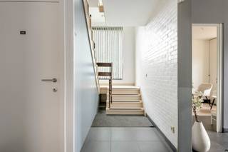 Op een rustige en groene locatie te Kapellen bevindt zich deze bijzondere opbrengsteigendom, ondergebracht in het voormalige gebouw van de rijkswacht. Het pand werd doorheen de jaren functioneel ingericht en opgesplitst tot een veelzijdige en volledig verhuurde vastgoedinvestering met een stabiele verhuurstructuur.
<p>Het geheel omvat vier woonentiteiten, drie praktijkruimten, vier uitzonderlijk ruime garages en enkele parkeerplaatsen op eigen terrein. Dankzij de combinatie van wonen, praktijkmogelijkheden en multifunctionele garages biedt deze eigendom tal van exploitatemogelijkheden, zowel voor investeerders als voor kandidaat-kopers met een langetermijnvisie.</p>
<p>De huurovereenkomsten lopen momenteel tot eind oktober 2027, waardoor de nieuwe eigenaar geniet van onmiddellijke en stabiele huurinkomsten, met tegelijk de mogelijkheid om nadien de verhuurstructuur verder te optimaliseren of een eigen invulling aan het gebouw te geven.</p>
<p>Indeling van het gebouw:</p>
<ul>
<li>
<p>Gelijkvloers: drie praktijkruimten met gemeenschappelijk gastentoilet en een appartement met twee slaapkamers</p>
</li>
<li>
<p>Eerste verdieping: een studio met aparte slaapkamer en een ruim appartement met twee slaapkamers</p>
</li>
<li>
<p>Tweede verdieping: een charmante loft onder het dak, voorzien van ingebouwde kasten, een aparte slaapkamer en bijkomende zolderruimte</p>
</li>
</ul>
<p>Alle woonentiteiten beschikken over een eigen badkamer met douche en lavabomeubel, een open keuken met keukenkasten, kookplaat en dampkap, alsook privatieve nutsvoorzieningen met individuele meters, wat zorgt voor een transparant en efficiënt beheer.</p>
<p>Een absolute troef van deze eigendom zijn de vier voormalige rijkswachtgarages. Deze garages zijn uitzonderlijk ruim en hoog, waardoor ze multifunctioneel inzetbaar zijn en zelfs geschikt zijn voor grotere voertuigen zoals campers, bestelwagens of extra opslagruimte.</p>
<p>Daarnaast behoudt het gebouw enkele authentieke elementen uit zijn verleden, waaronder de oorspronkelijke gepantserde deuren, die bijdragen aan het unieke karakter van het geheel. Onder het volledige gebouw bevindt zich bovendien een kruipruimte.</p>
<p>Een zeldzame opportuniteit voor wie op zoek is naar een karaktervolle opbrengsteigendom met stabiele inkomsten, toekomstpotentieel en een uitstekende ligging in Kapellen.</p>