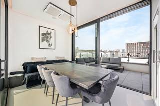 <span>Indeling</span>: <br />Gelegen in de gegeerde Pacificatiestraat te Antwerpen presenteert deze uitzonderlijke woning zich als een harmonieus samenspel van luxe, comfort en verfijnde architectuur. De totaalrenovatie werd uitgevoerd in 2019 met een eerste ingebruikname in 2022, waarbij elk detail met de grootste zorg werd afgewerkt. Hoogwaardige parketvloeren en stijlvolle gietvloeren versterken de moderne en warme uitstraling, terwijl de overvloedige lichtinval en de zuidgerichte oriëntatie de ruimtes een bijzonder aangenaam karakter geven. De woning is volledig instapklaar met een EPC-score B en conforme elektriciteit, en werd uitgerust met een geavanceerd domoticasysteem, alarmsysteem en digicode, wat veiligheid en gebruiksgemak perfect combineert. Vloerverwarming, aangevuld met radiatoren waar gewenst, zorgt voor optimaal comfort, terwijl een lift die alle niveaus verbindt, van de kelder tot het dakterras op de vierde verdieping.<br /><br />De kelderverdieping omvat een mooie wijnkelder en een praktische wasruimte. Op het gelijkvloers bevindt zich een inkomhal met toegang tot een volwaardig geïntegreerd “appartement”: een leefruimte met volledig uitgeruste keuken, een aparte slaapkamer met ensuite badkamer voorzien van inloopdouche en een koertje van 4,65 m². Deze ruimte leent zich perfect als kangoeroewoning, gastenverblijf of derde slaapkamer, en maakt integraal deel uit van de woning. De eerste verdieping herbergt een royale slaapkamer van circa 18 m² met dressing en een stijlvolle badkamer met inloopdouche. Op de tweede verdieping bevindt zich een tweede ruime slaapkamer van ongeveer 22 m² met ensuite badkamer, uitgerust met zowel bad als inloopdouche.<br /><br />De derde verdieping vormt het hart van de woning met een lichtrijke leefruimte en open keuken, die rechtstreeks toegang biedt tot een terras van 8 m². Via een trap (of met de lift) bereikt u het vierde niveau, waar twee ruime zonneterrassen verbonden worden door een unieke zomerkeuken/binnenlounge met schuifdeuren aan beide zijden. Deze harmonieuze buitenbeleving biedt een prachtig, vrij zicht over de omliggende daken en volledige privacy zonder inkijk. <br /><br />De slaapkamers zijn voorzien van maatwerk inbouwkasten en de woning ademt doorheen alle verdiepingen een gevoel van rust en verfijning.<br /><br />Daarnaast bestaat de mogelijkheid tot aankoop van twee ondergrondse binnenparkings onder de Carrefour: een afgesloten garagebox aan 65.000 euro en een autostaanplaats aan 45.000 euro, beide optioneel maar beschikbaar.<br /><br /><br /><span>Omgeving</span>:<br />De Pacificatiestraat geniet van een uiterst gegeerde ligging op het Zuid, één van de meest dynamische en stijlvolle buurten van Antwerpen. Hier woont u in een rustige straat met een residentieel karakter, terwijl u zich op wandelafstand bevindt van tal van trendy restaurants, gezellige cafés, boetieks en culturele hotspots. De nabijheid van het Museum van Schone Kunsten, de vernieuwde Scheldekaaien en verschillende parken zorgt voor een aangename combinatie van stadsleven en ontspanning.<br /><br />Dankzij de uitstekende bereikbaarheid met zowel het openbaar vervoer als belangrijke invalswegen verplaatst u zich vlot in en rond de stad. Fietsers en wandelaars genieten bovendien van de nabijgelegen groene zones en de levendige pleinen die deze buurt zo aantrekkelijk maken. De omgeving staat bekend om haar architecturale charme, brede straten en kwalitatieve residenties, wat bijdraagt aan een exclusieve en aangename woonbeleving.