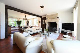 Deze karaktervolle villa is gelegen op een perceel van 951 m² en werd opgetrokken in 1986, met oog voor kwaliteit en duurzaamheid. In de loop der jaren werden bovendien diverse opfrissingswerken uitgevoerd, waaronder de installatie van een nieuwe keuken, een aircosysteem, een zonneluifel en de plaatsing van tien zonnepanelen. De ruime inkomhal met gastentoilet geeft toegang tot de lichtrijke woon- en eetkamer, die dankzij de grote raampartijen uitkijkt op het omliggende groen en de fraai aangelegde tuin. Aansluitend bevindt zich de volledig uitgeruste keuken, voorzien van kwalitatieve inbouwtoestellen van het merk Miele. Vanuit de keuken bereikt u een koele berging en de dubbele inpandige garage. Op het gelijkvloers bevindt zich eveneens een royale bureauruimte aan de voorzijde van de woning. De eerste verdieping omvat vier volwaardige slaapkamers, een dressing/berging en een ruime badkamer uitgerust met een ligbad, een inloopdouche, een toilet en een dubbele wastafel. De zolderverdieping is bereikbaar via een uitschuifbare trap vanuit één van de slaapkamers en biedt extra opbergruimte. De tuin is volledig volgroeid en biedt voldoende rust en privacy. Dankzij de zuidwestelijke oriëntatie kunt u hier volop genieten van de zon.<br /><br />Ook de ligging is hier een bijzonder grote troef gezien de ringweg slechts op 500 meter afstand ligt met de oprit naar de A17. <br /> <br />Benieuw? guillian@landbergh.be of 09 278 78 79.