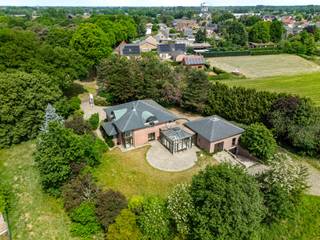 Deze unieke villa is gelegen op een ruime perceel van maar liefst 4.435 m² in het rustige Dessel en biedt de perfecte balans tussen ruimte en rustige omgeving. Met zijn doordachte indeling is deze woning ideaal voor gezinnen die op zoek zijn naar veel ruimte, zowel binnen als buiten.<br /><br />Deze woning combineert ruimte, stijl en privacy!<br /><br />Gelijkvloers: <br />Bij binnenkomst in de woning komt u direct in de inkomhal met een gastentoilet. De inkomhal geeft toegang tot een bureau/kantoorruimte, perfect voor thuiswerken of als ontspanningsruimte. De open leefruimte is een waar middelpunt van de woning, met een gezellige zithoek en een ruime eethoek. Dankzij de grote ramen geniet u hier van veel natuurlijk licht, wat een aangename, luchtige sfeer creëert. De open keuken is volledig uitgerust en biedt alles wat u nodig heeft om heerlijke maaltijden te bereiden. Aangrenzend vindt u een praktische koele berging en een tuinkamer die uitkijkt op de grote tuin.<br /><br />Verder op het gelijkvloers bevindt zich een comfortabele slaapkamer, ideaal voor wie gelijkvloers wil slapen, en een ingerichte badkamer. Een aparte wasplaats biedt extra functionaliteit, en de dubbele inpandige garage biedt plaats aan twee voertuigen en biedt extra bergruimte.<br /><br />Verdieping: <br />Op de bovenverdieping vindt u een grote polyvalente ruimte die kan dienen als speelkamer, hobbyruimte of zelfs een tweede woonkamer. De verdieping biedt verder drie ruime slaapkamers, elk met voldoende ruimte en daglicht. Deze kamers kunnen naar wens ingericht worden, van kinderkamers tot logeerkamers of een aparte dressing.<br /><br />Kelder: <br />De woning is volledig onderkelderd, wat een enorme meerwaarde biedt in termen van opslag en ruimte. Of u nu een wijnkelder, een hobbyruimte of extra bergruimte wenst, de kelder biedt talloze mogelijkheden. Hier is tevens een extra garage voorzien.<br /><br />Tuin en omgeving: <br />De villa is omgeven door een ruime tuin met volop mogelijkheden voor buitenactiviteiten, ontspanning of zelfs het aanleggen van een moestuin. De rustige ligging in Dessel biedt veel privacy, maar toch bent u op korte afstand van alle nodige voorzieningen en belangrijke verbindingswegen.<br /><br />Bijzonderheden<br />-Gunstig EPC<br />-Mooie en rustige omgeving<br />- Op de verdieping zijn er in één van de kamers voorzieningen getroffen voor het inrichten van een 2de badkamer<br />- Zeer gunstige EPC score (B-klasse)